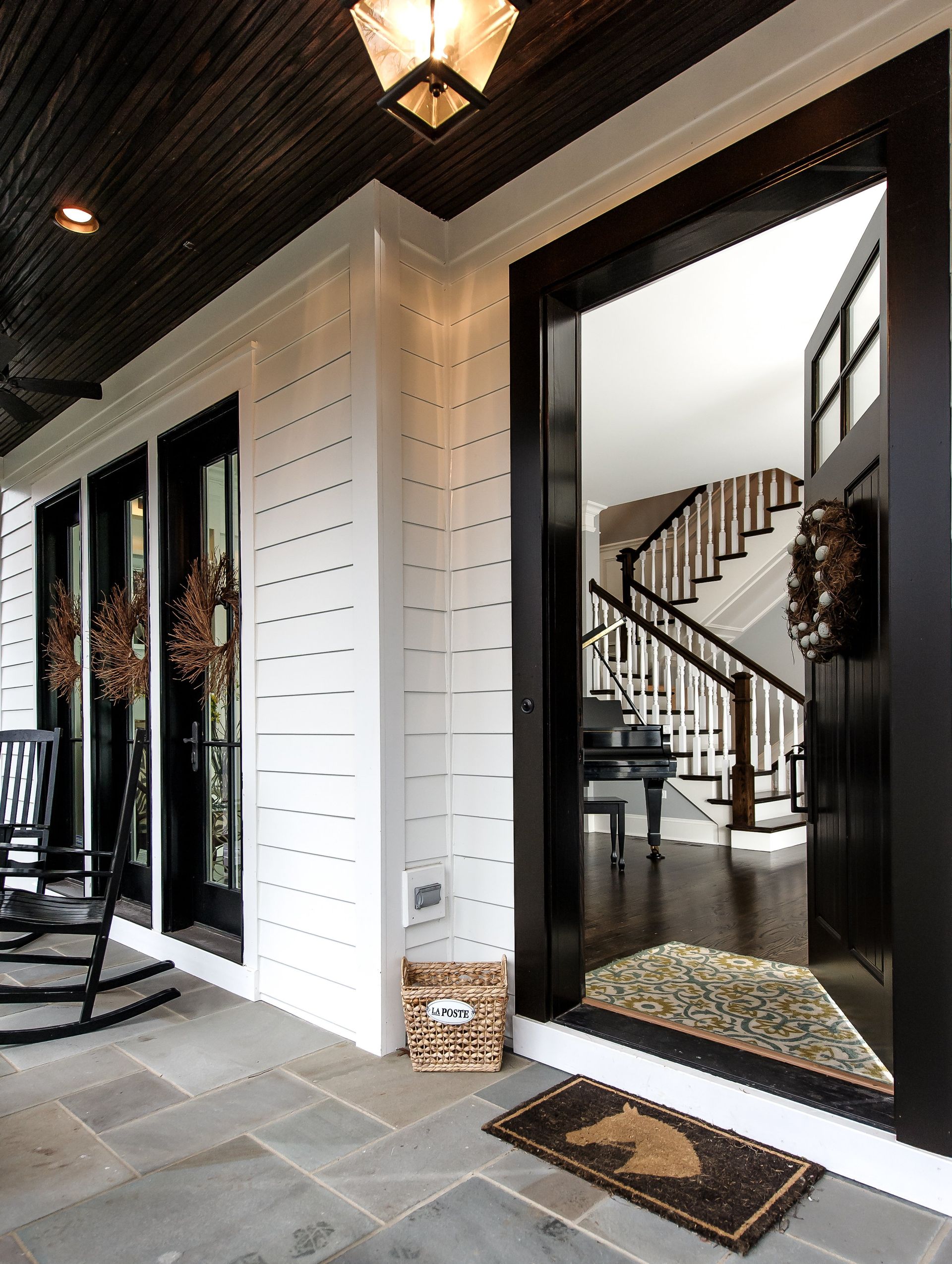 A porch with a rocking chair and stairs in the background
