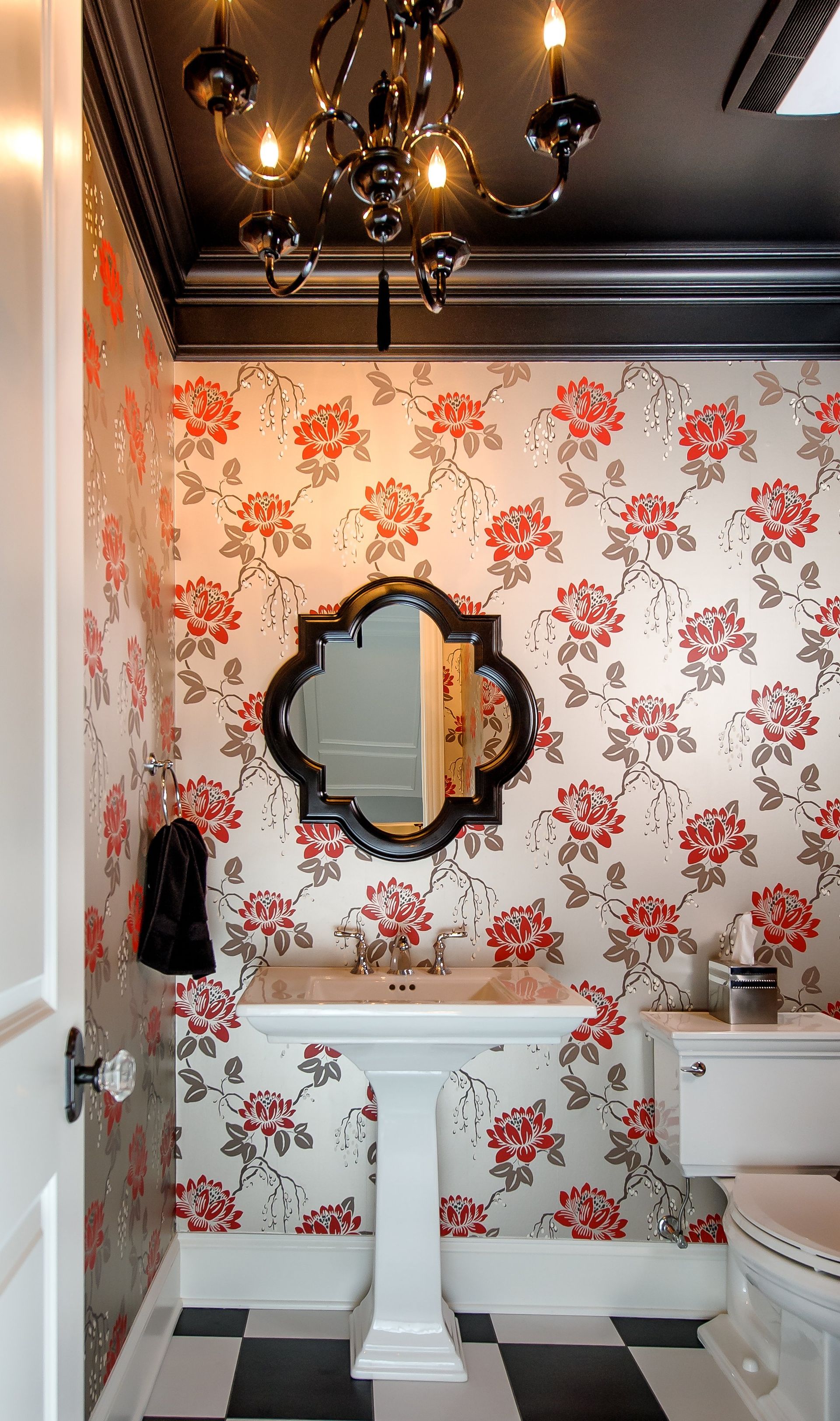 A bathroom with floral wallpaper and a chandelier