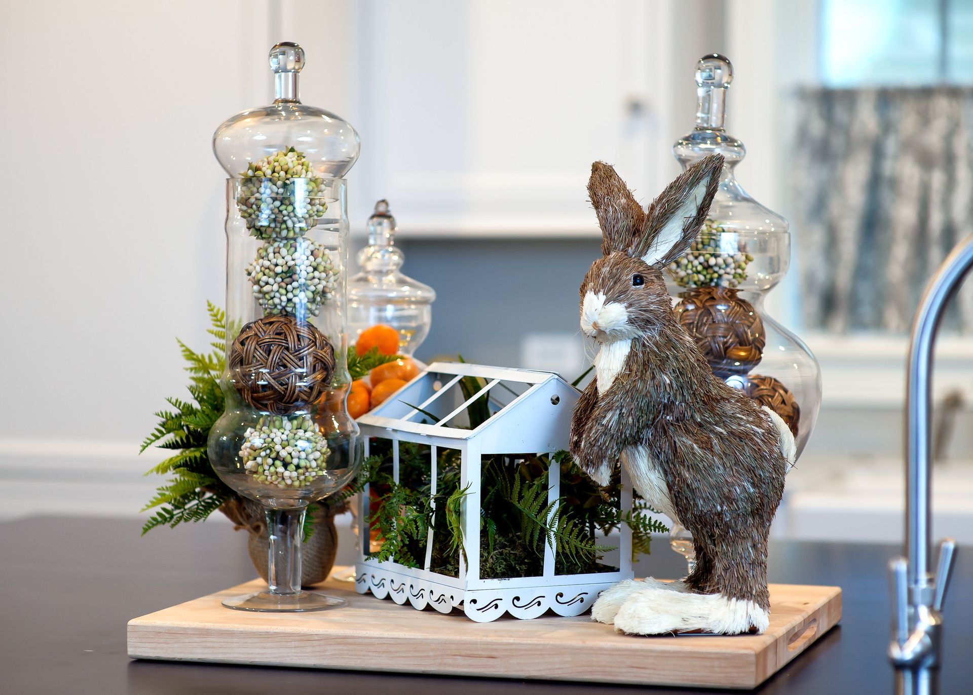A rabbit is sitting on a cutting board next to a greenhouse.