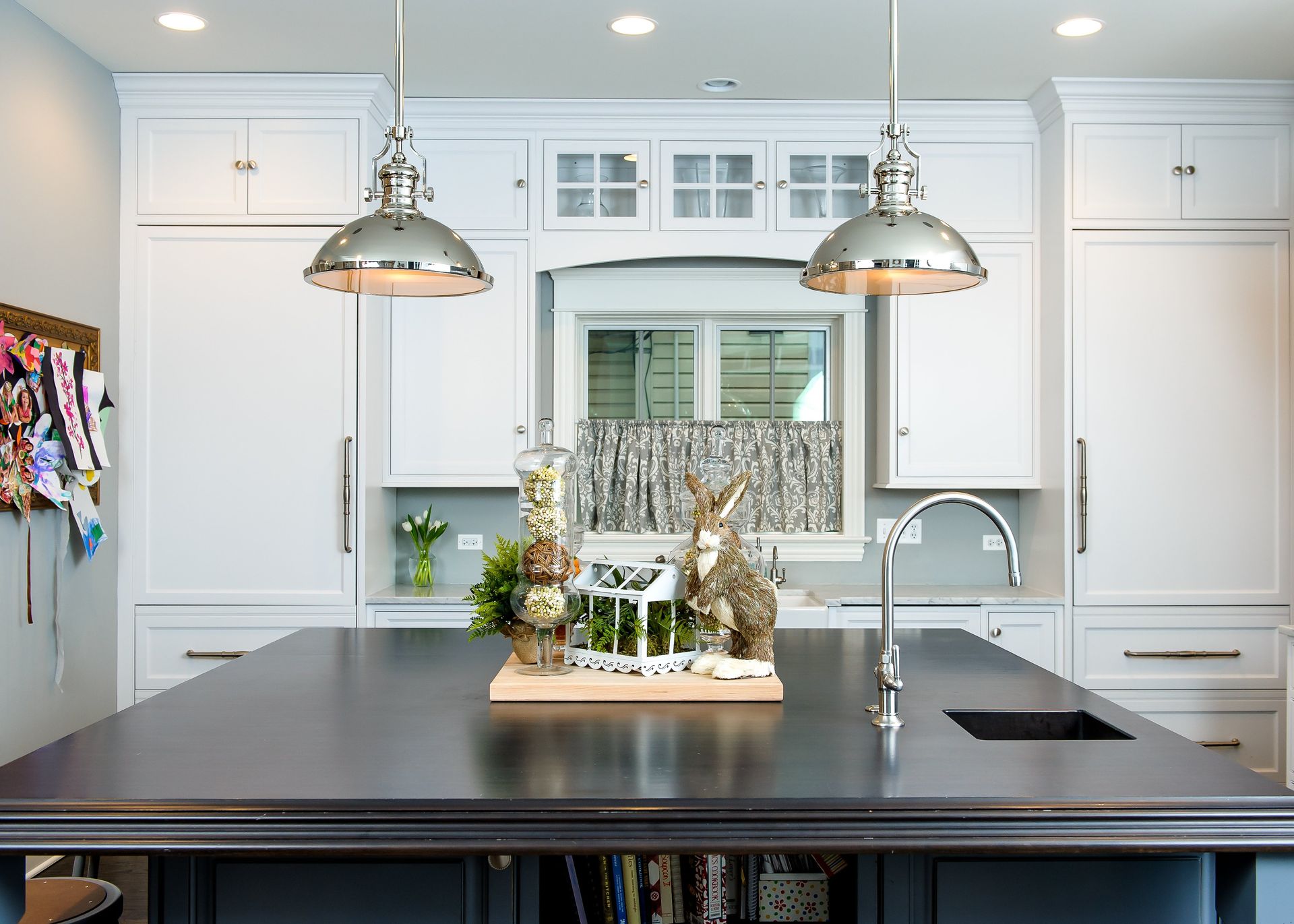 A kitchen with white cabinets and a black counter top