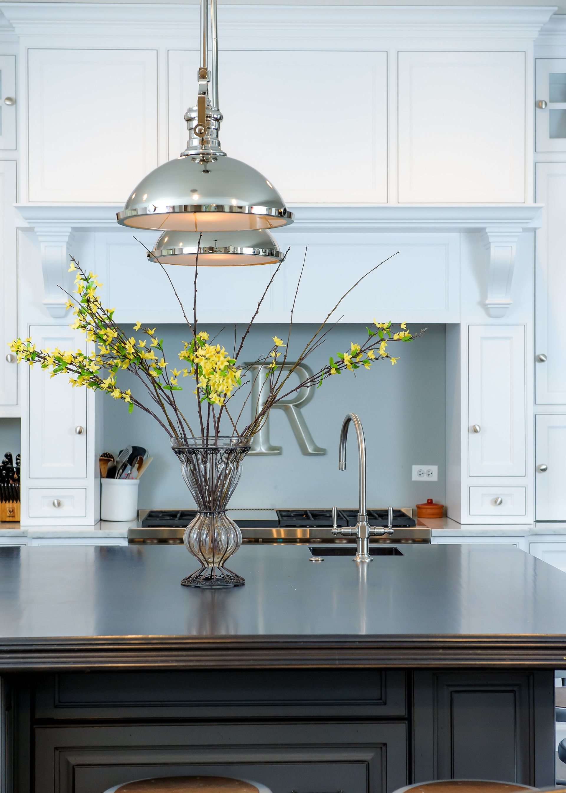 A kitchen with a stainless steel counter top and a vase of flowers on it