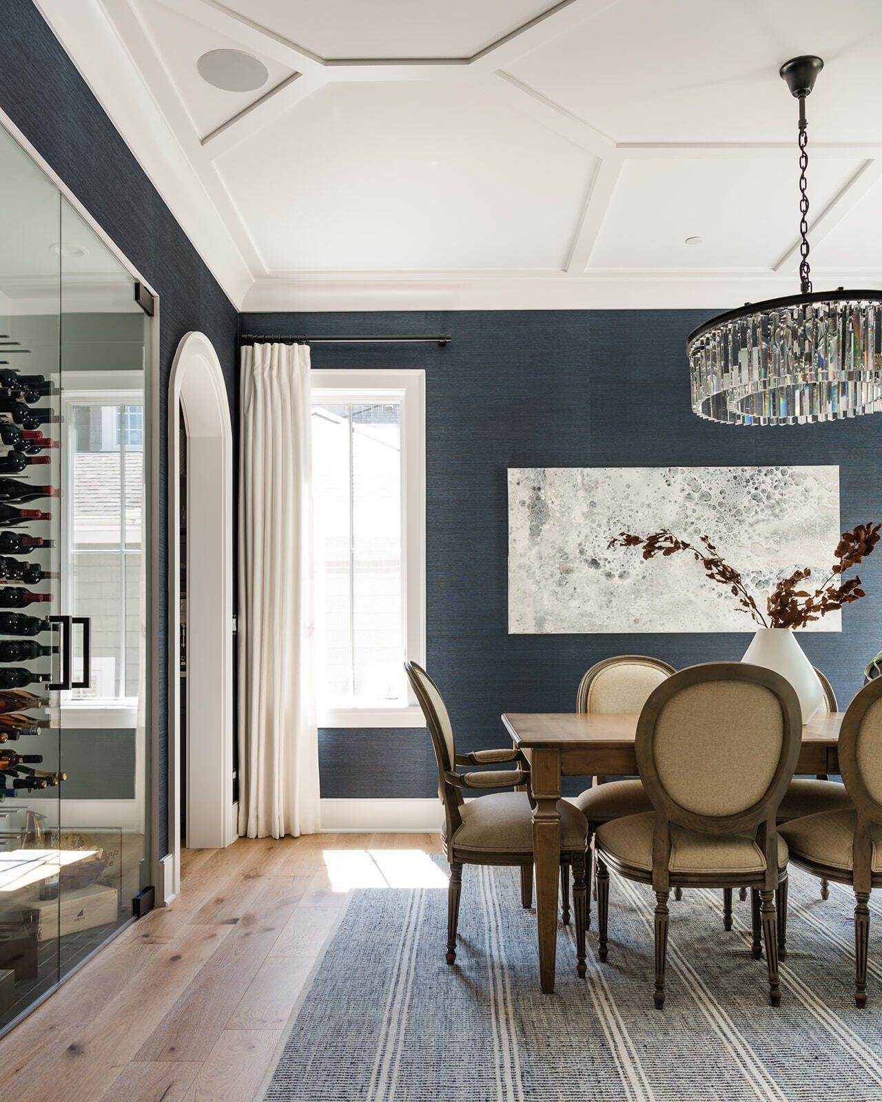 A dining room with a table and chairs and a wine cellar