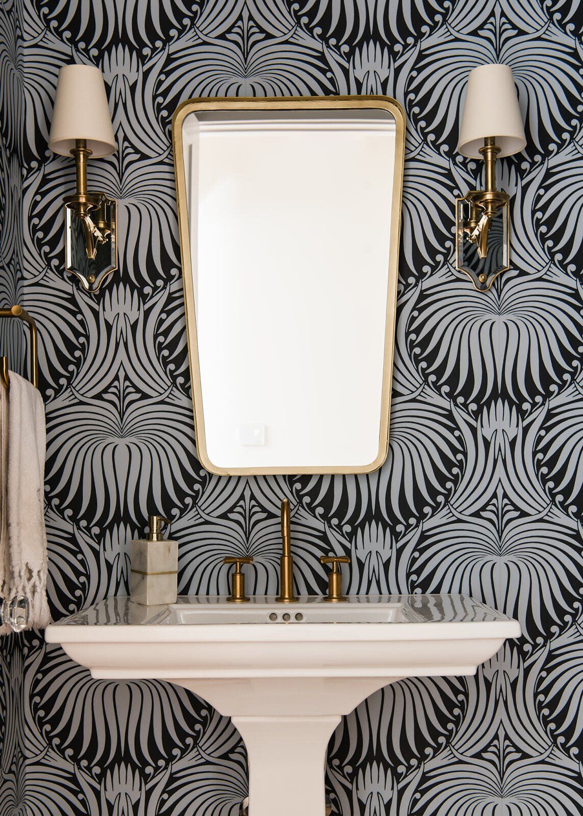 A bathroom with a sink , mirror , and lamp.