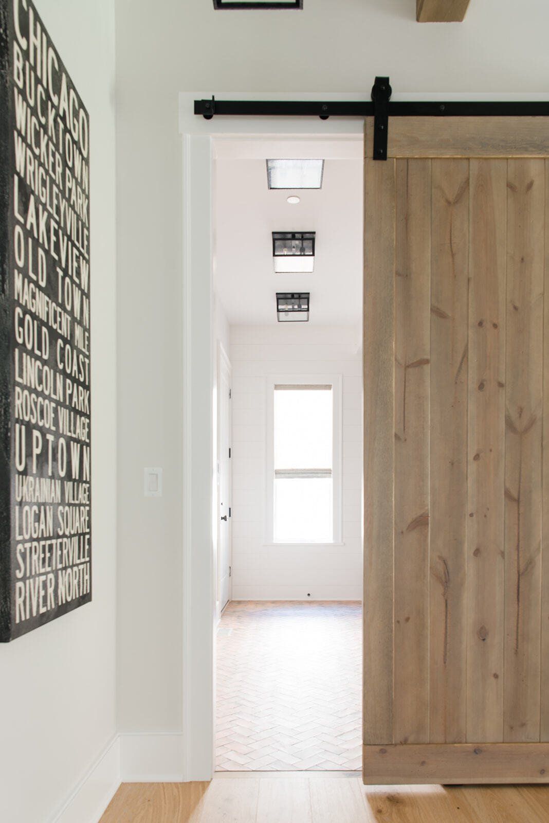 A hallway with a sliding barn door and a sign on the wall.