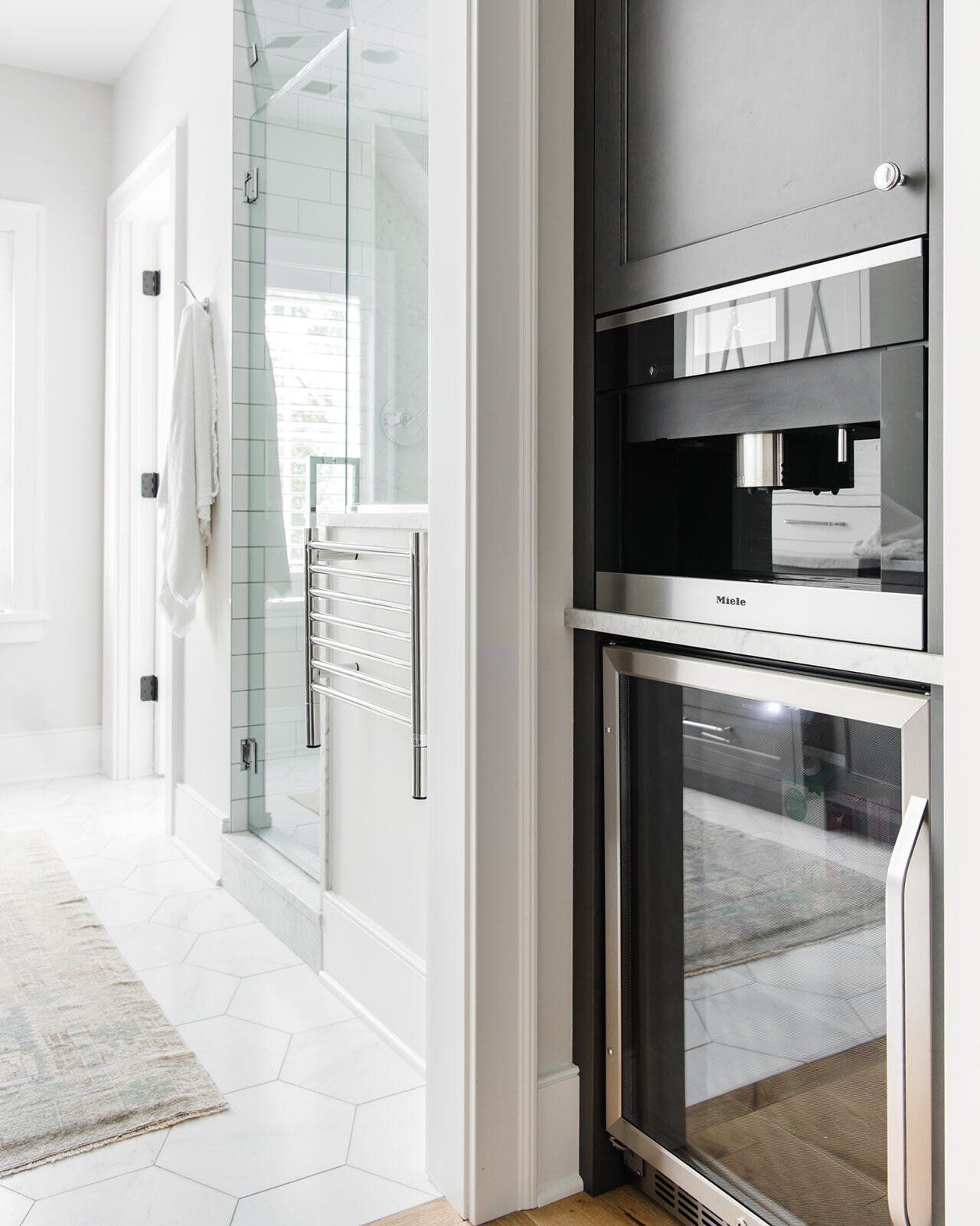 A kitchen with a stainless steel oven and a glass door.