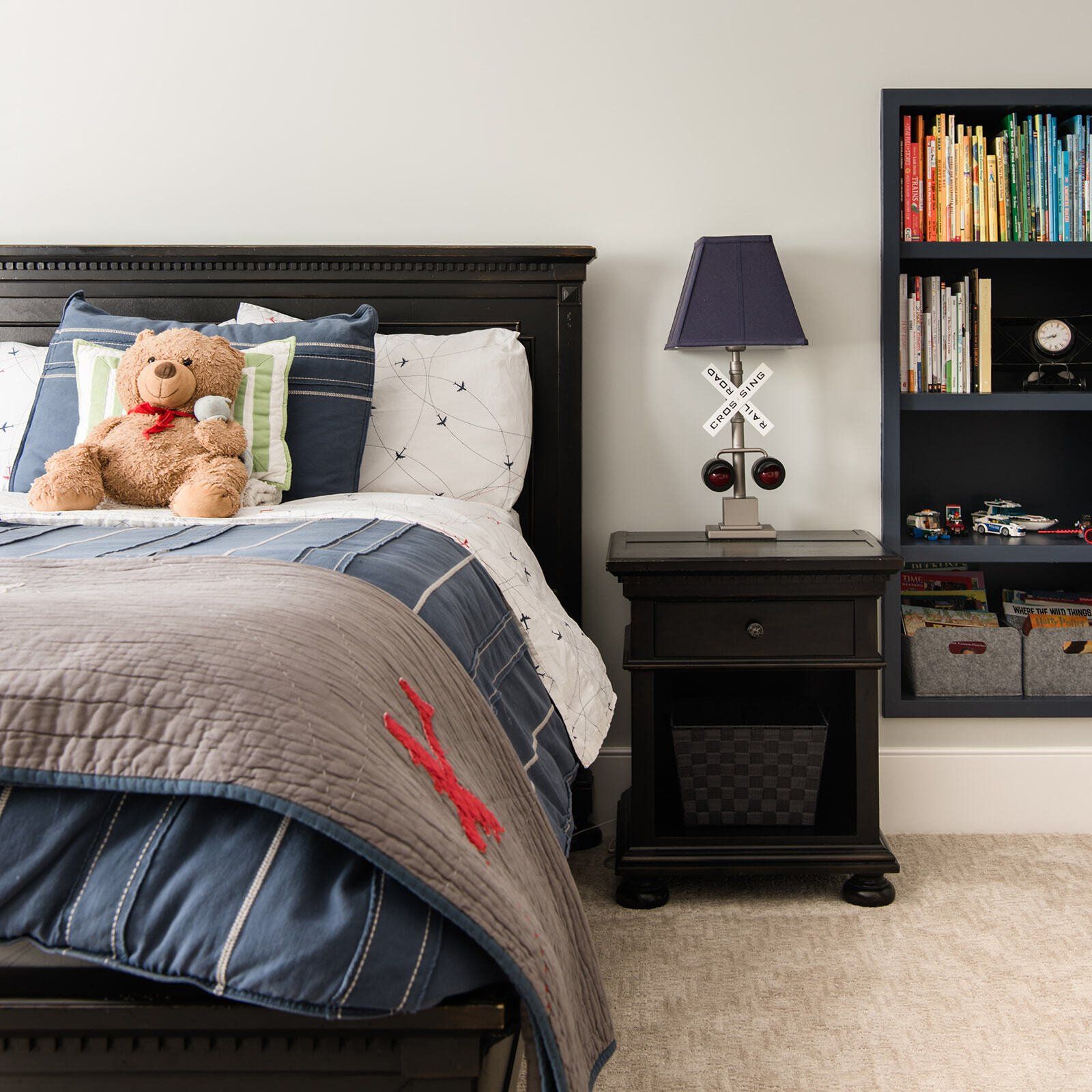 A bedroom with a teddy bear on the bed