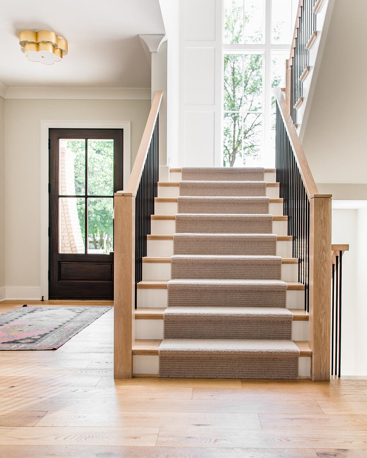 A staircase with a carpeted staircase leading up to the second floor of a house.