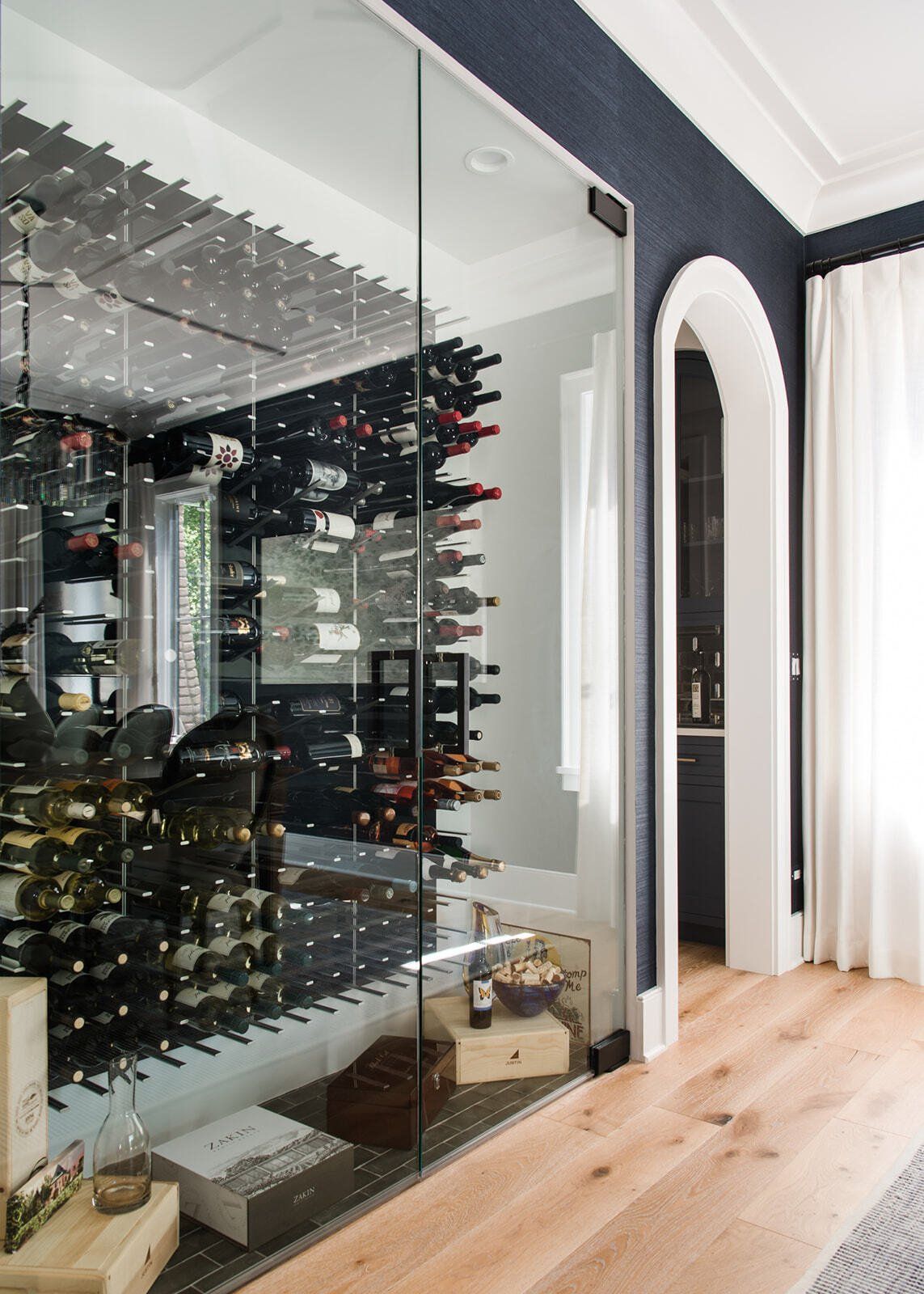 A wine cellar with bottles of wine behind a glass wall.