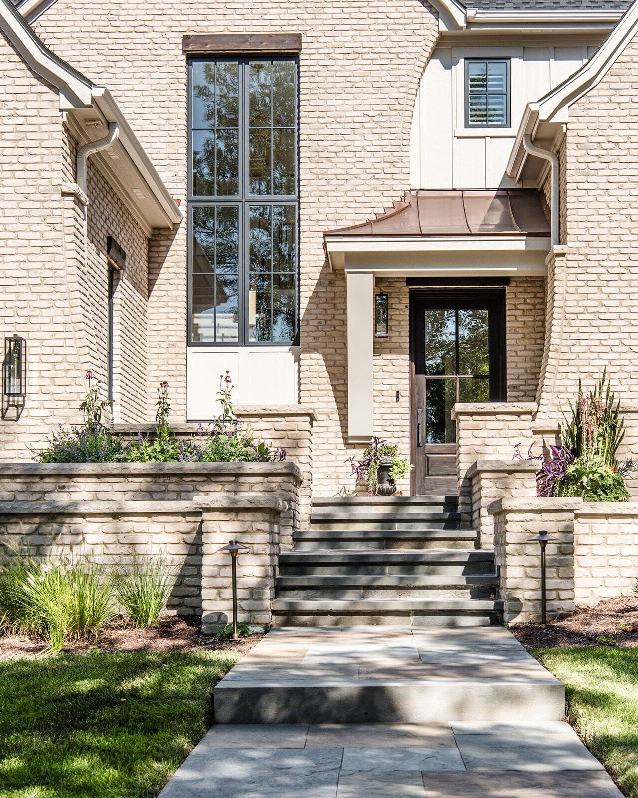 A brick house with a stone walkway leading to the front door.