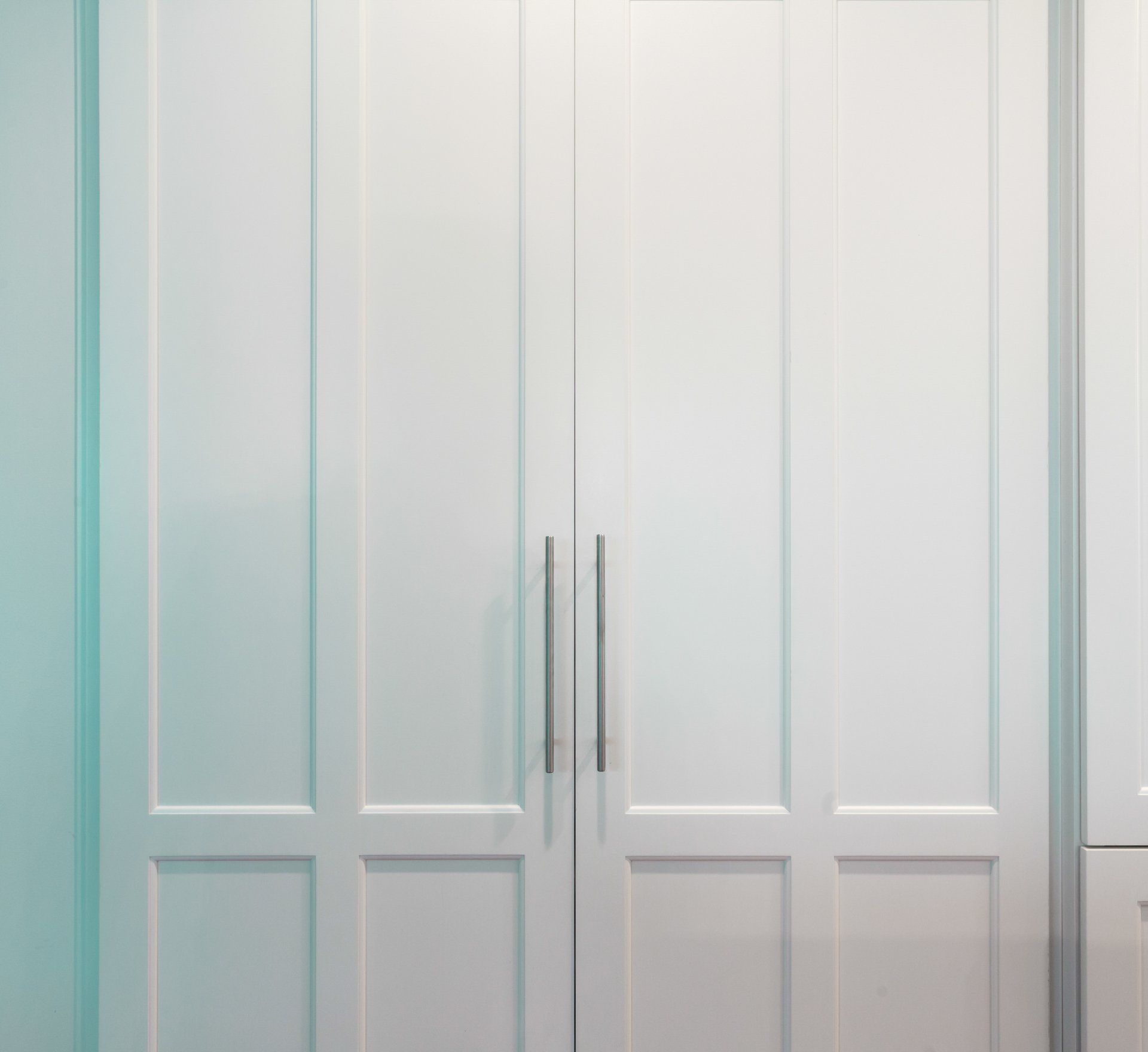 A close up of a white wardrobe with two doors.