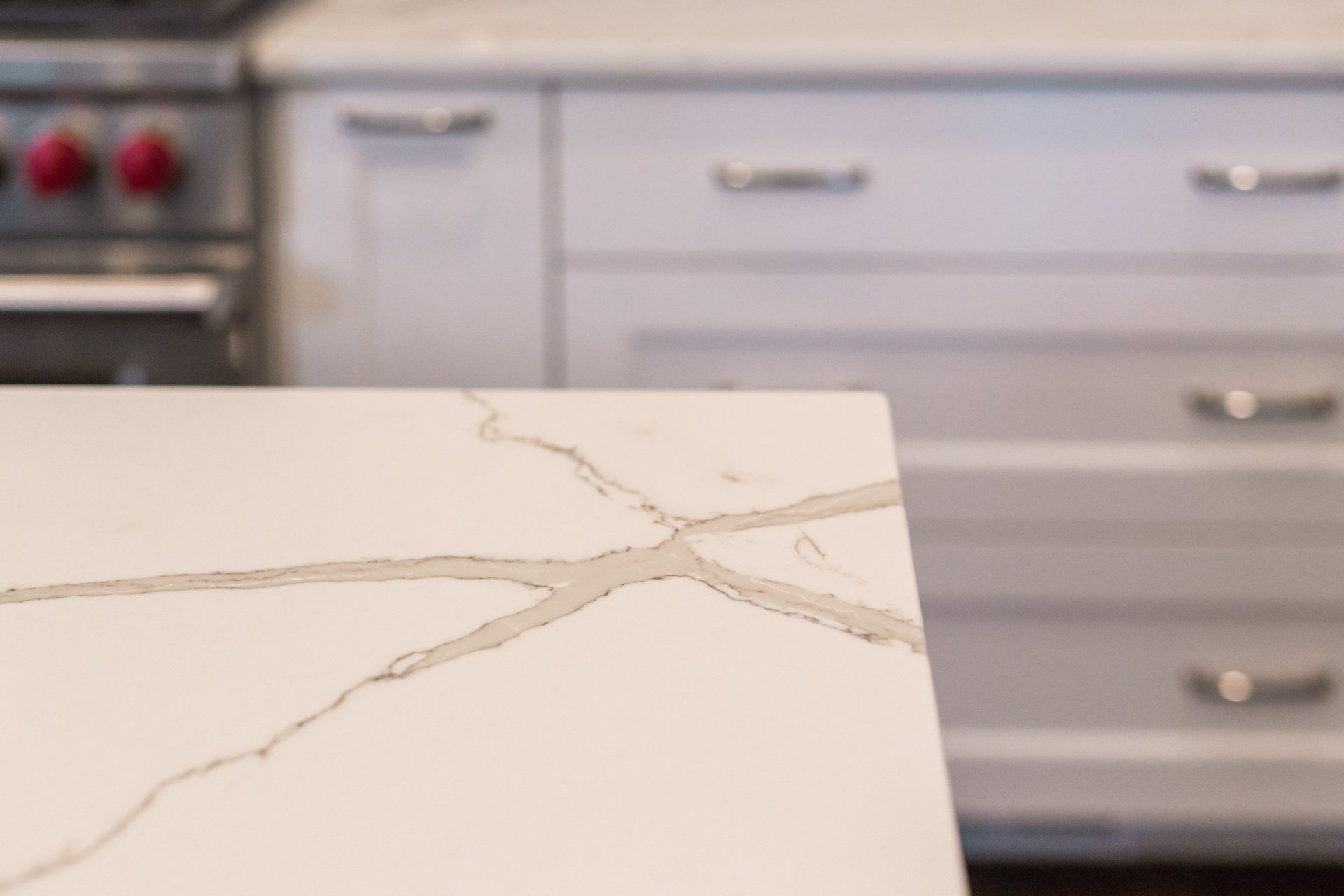 A close up of a counter top in a kitchen with a stove in the background.