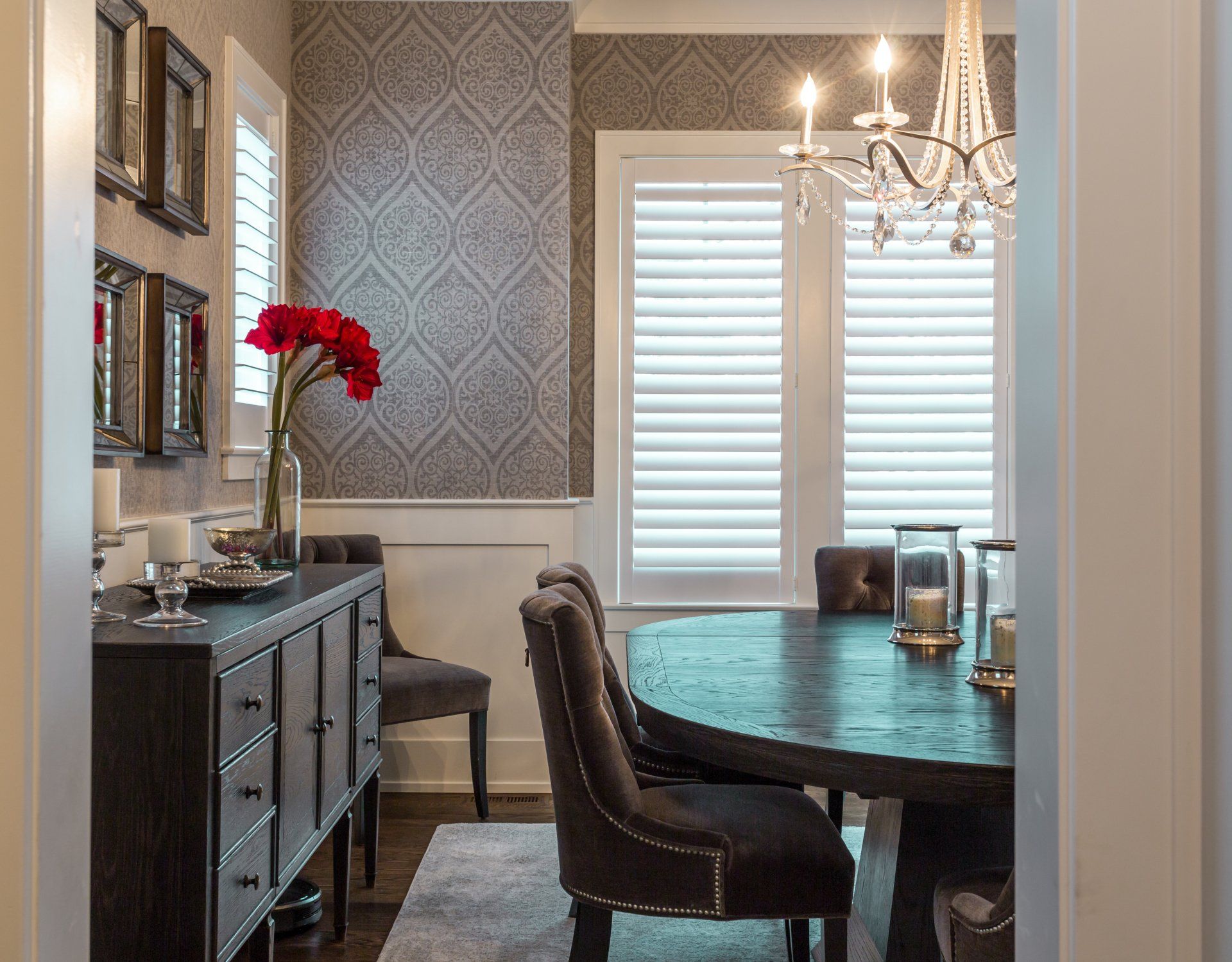 A dining room with a round table and chairs and a chandelier