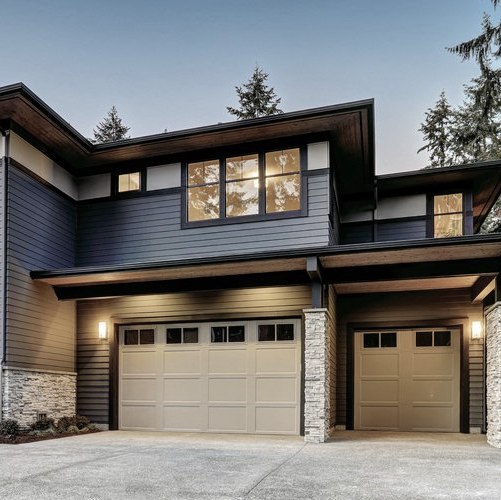 A large house with two garage doors and a lot of windows