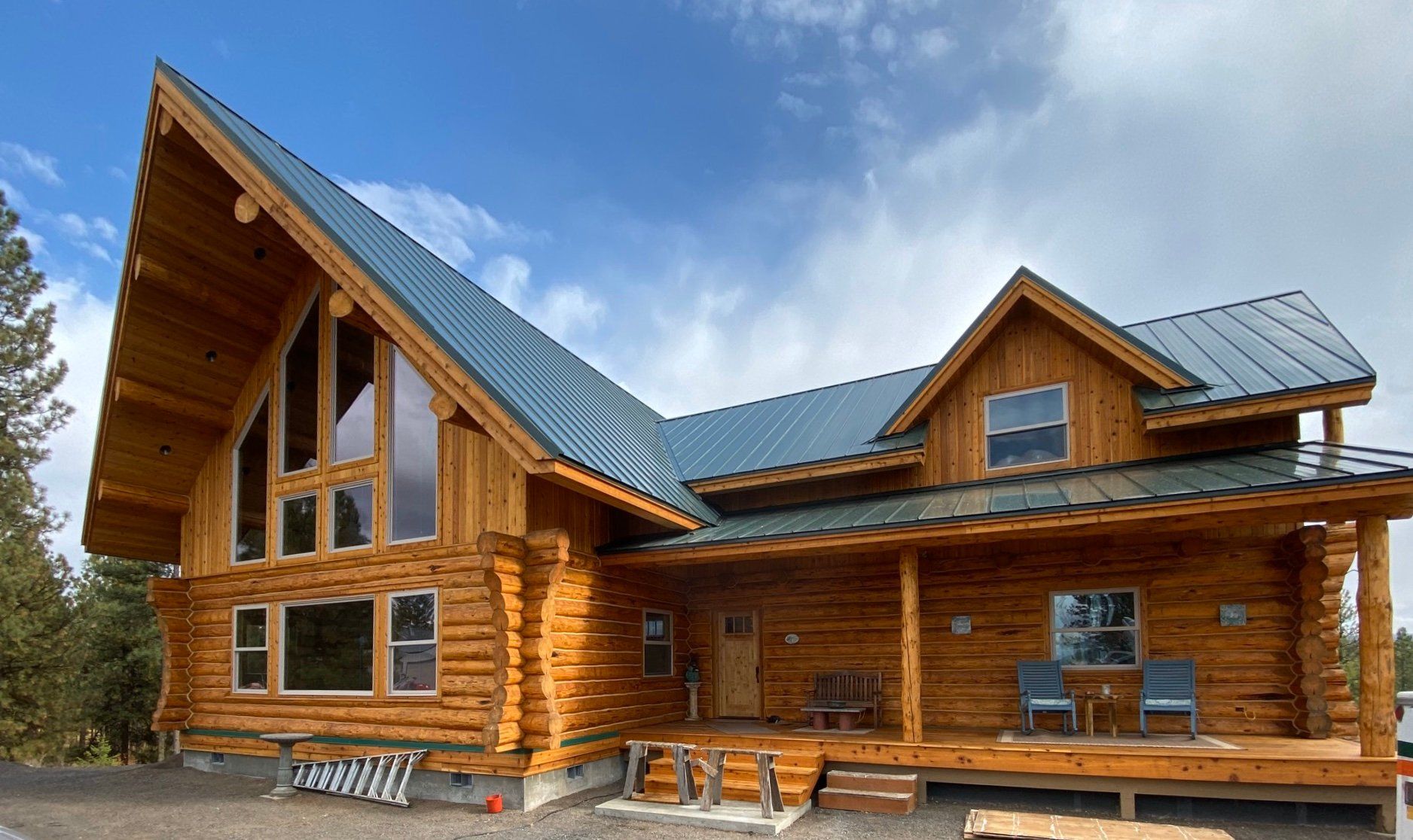 A large log cabin with a metal roof and lots of windows