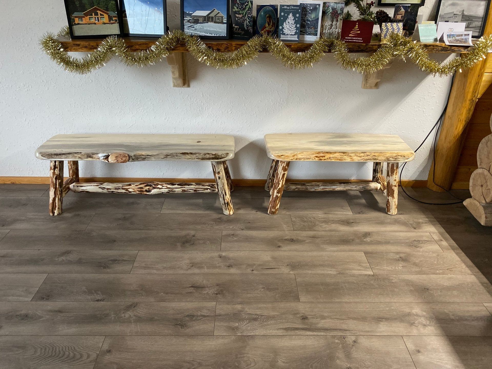 Two wooden benches are sitting on a wooden floor in a room.