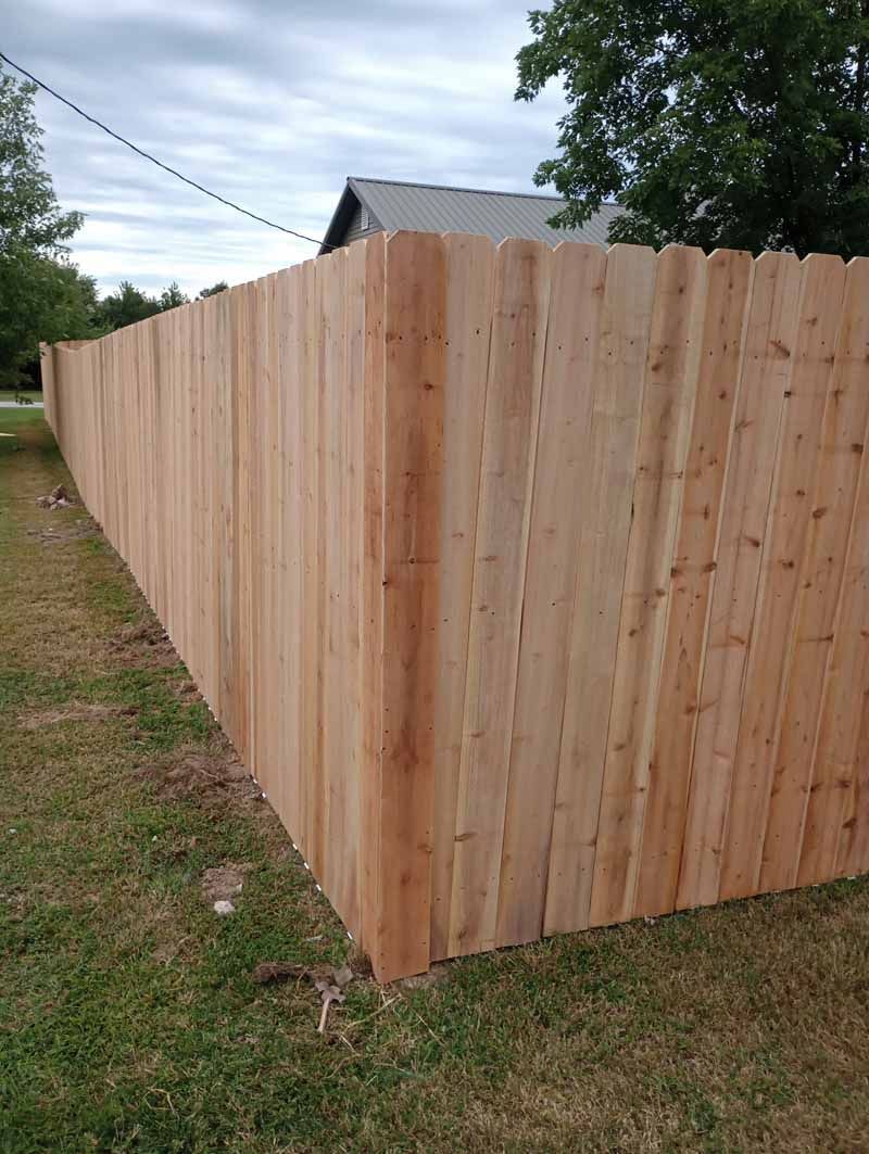 Wooden privacy fence in a grassy yard.