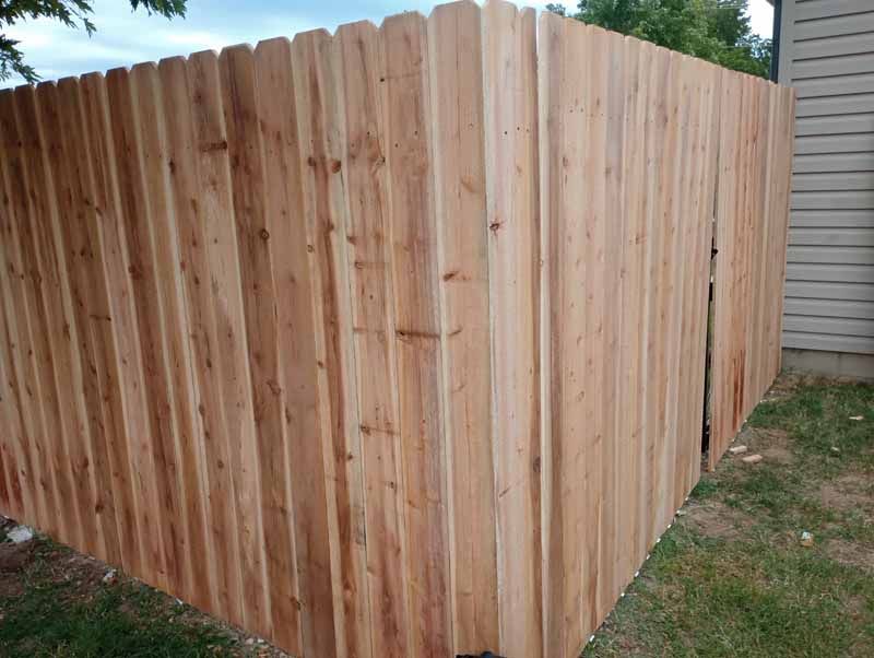 Wooden privacy fence in a grassy yard.
