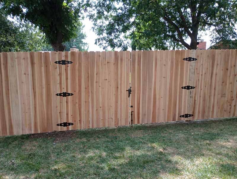 Wooden fence with gate; black hinges, latch.