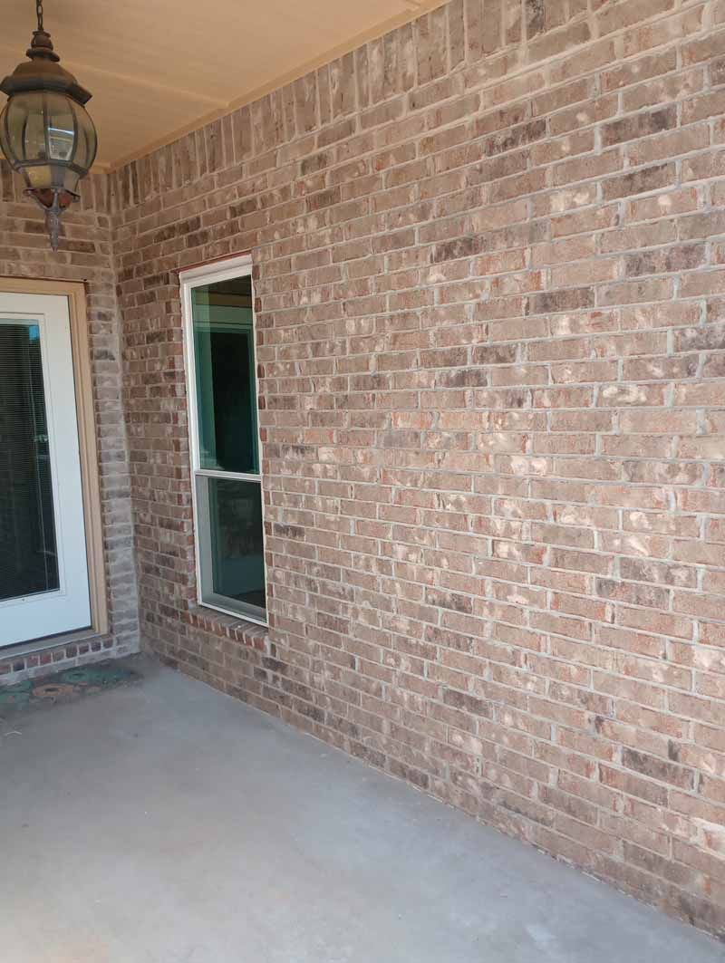 Brick exterior with a window, door, and porch overhang.
