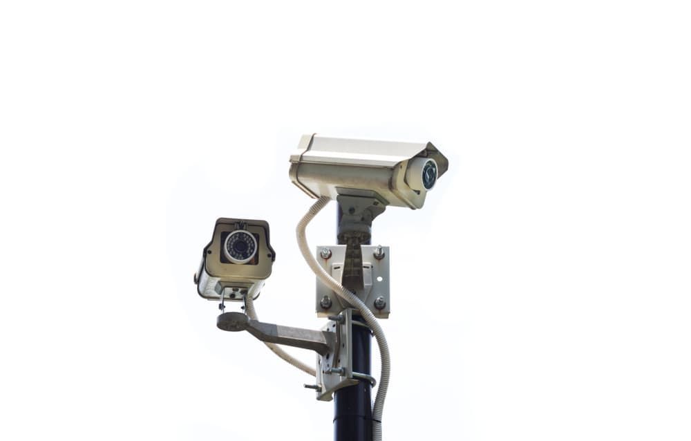 Two Security Cameras on a Pole on a White Background — BNCC Security Services in Port Macquarie, NSW