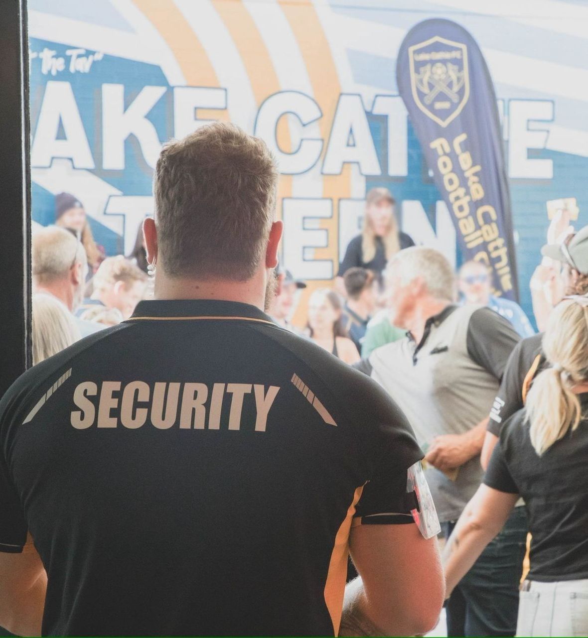 A man wearing a security shirt stands in front of a crowd — BNCC Security Services in Port Macquarie, NSW