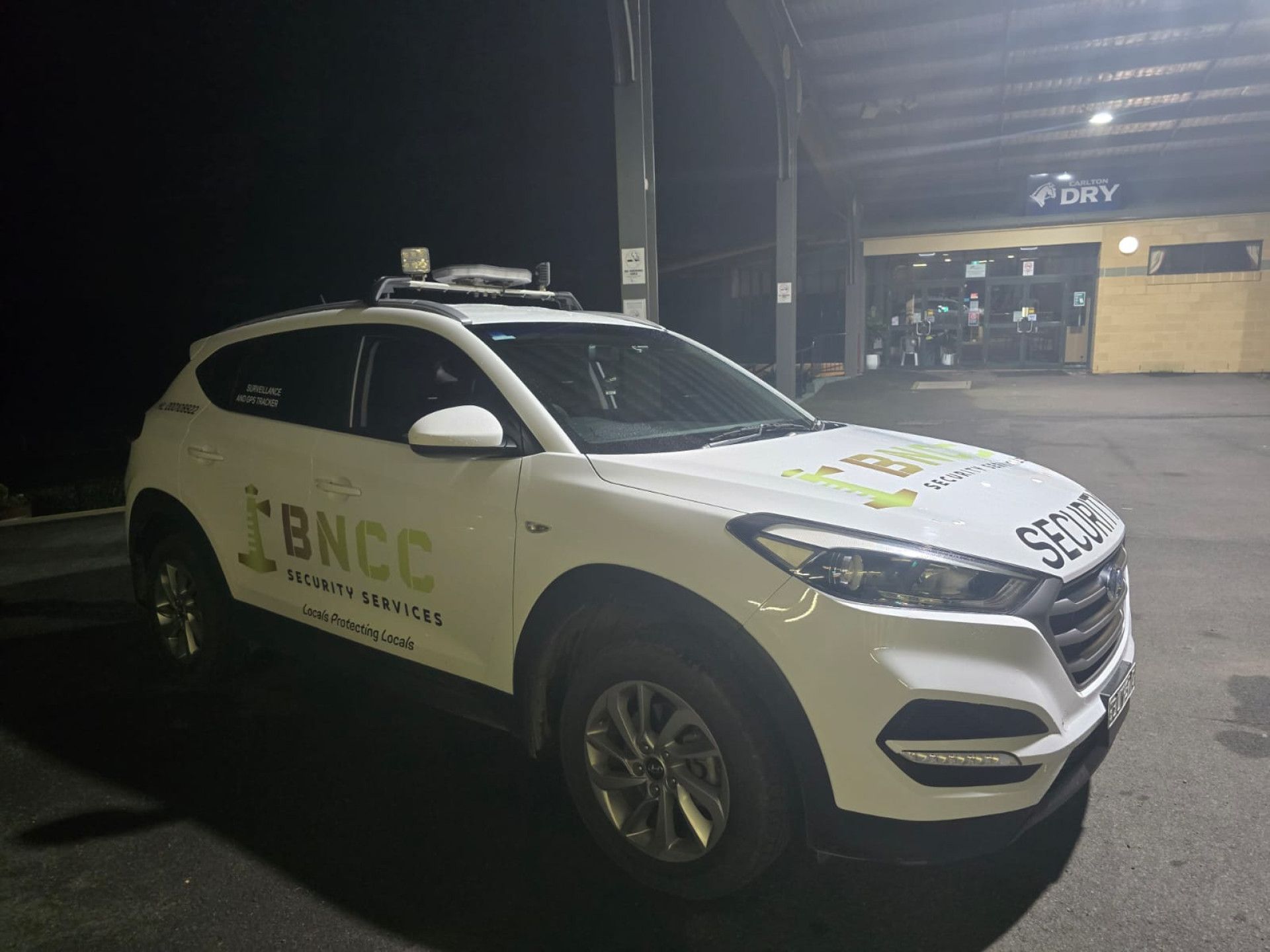 A White Police Car With Red and Blue Lights on Top of It — BNCC Security Services in Port Macquarie, NSW