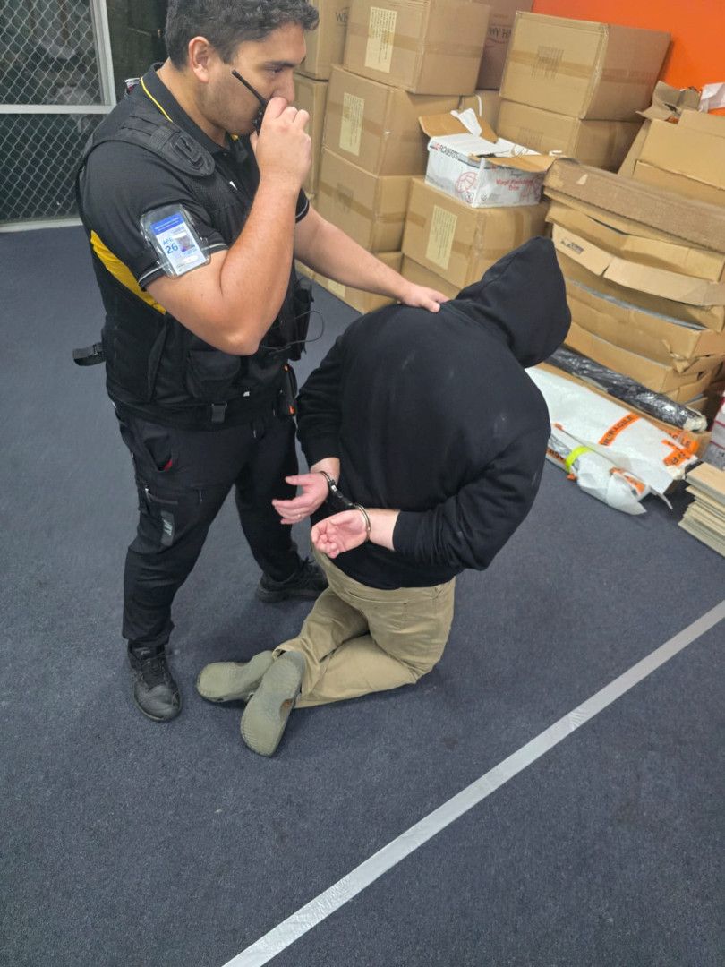 A security guard talking on a 2way and holding a suspect down on handcuffs — BNCC Security Services in Port Macquarie, NSW