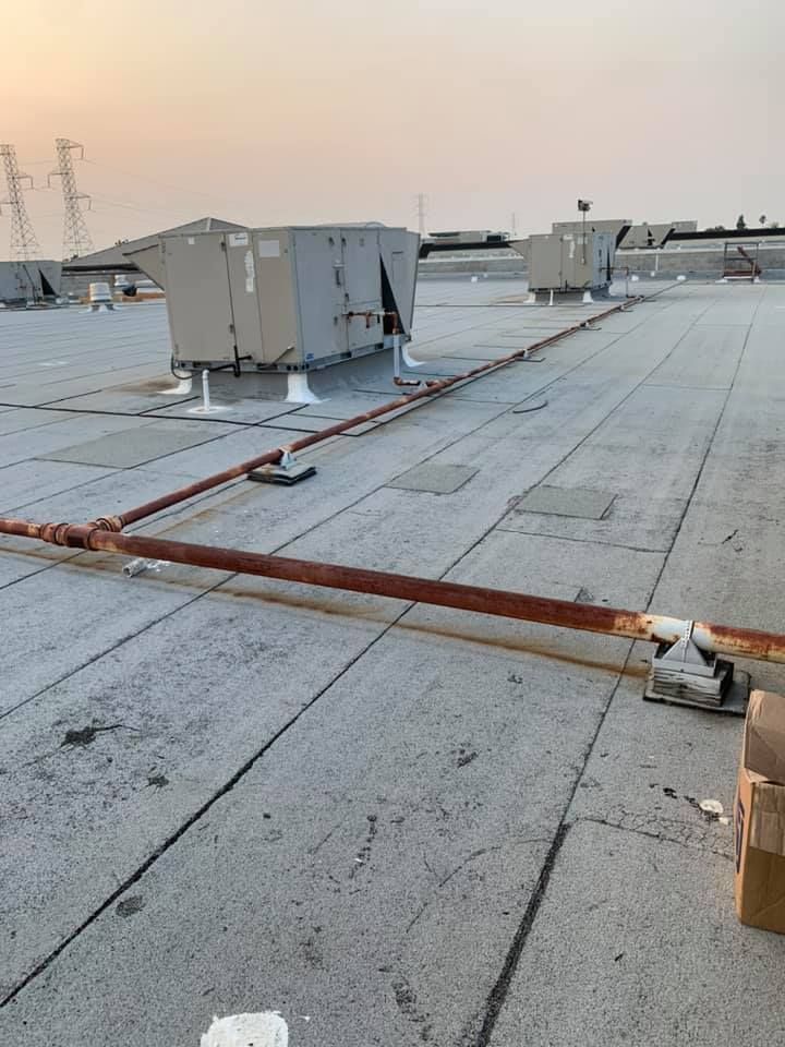 The roof of a building with a lot of pipes on it.