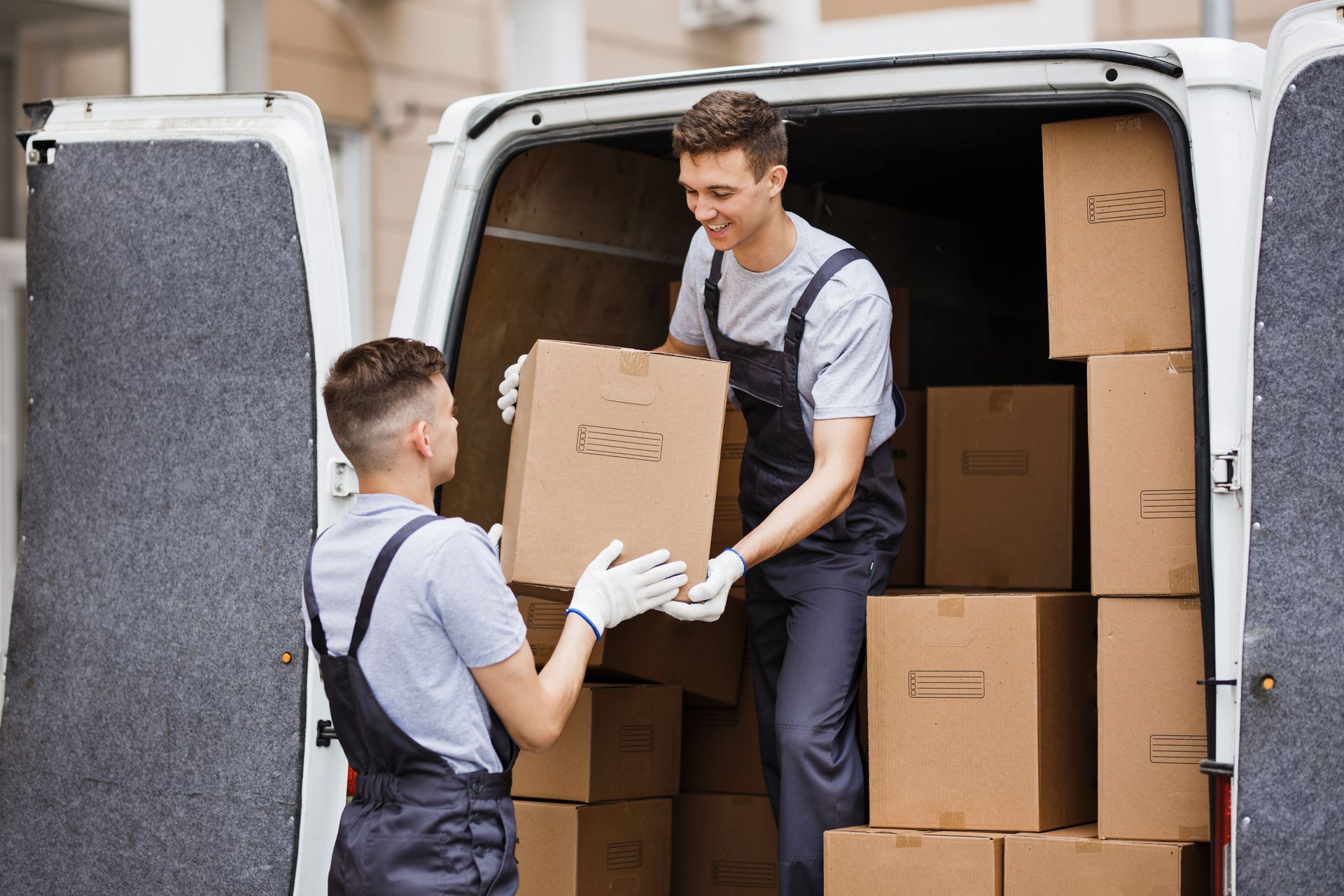 Two men are loading boxes into a van.