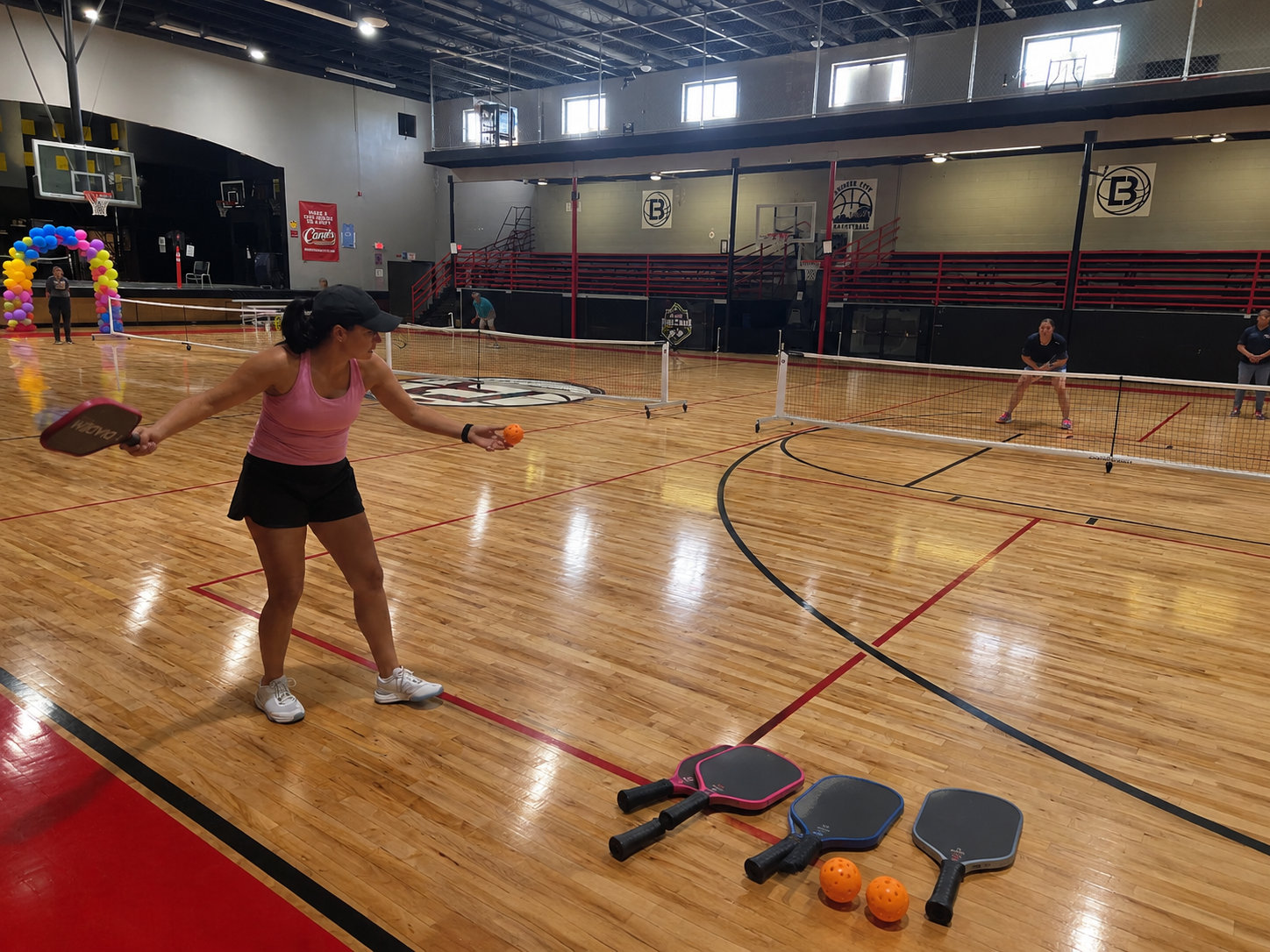 Indoor pickleball court at Sun City Pickleball Club El Paso with players warming up before tournament play
