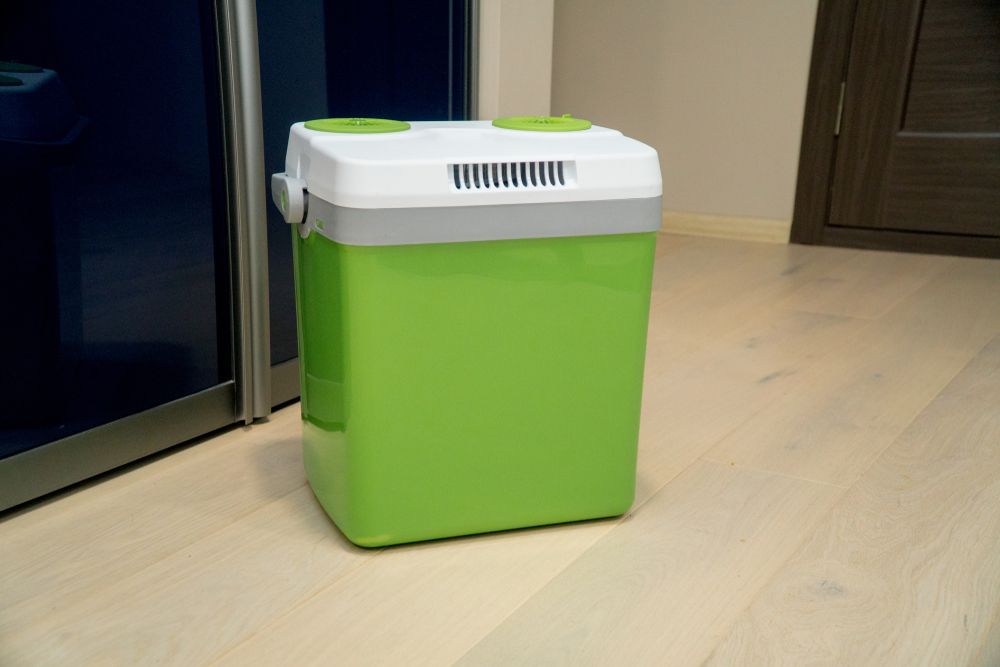 Green and White Portable Cooler on A Light Wood Floor — Lakeside Gas Fridges In Cessnock, NSW