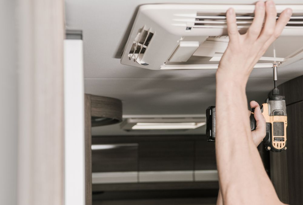 Person Installing an Air Conditioner Unit — Lakeside Gas Fridges In Argenton, NSW