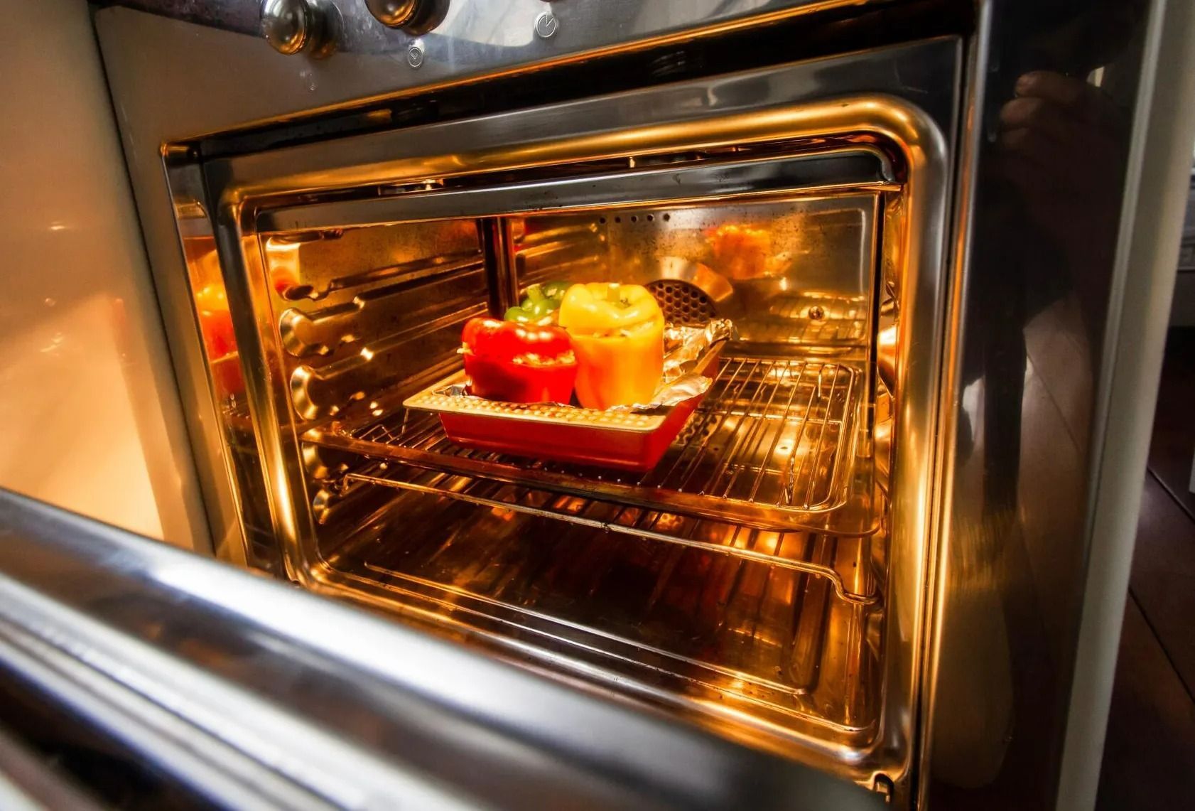 Open Oven with A Red and Yellow Bell Pepper Dish Baking Inside — Lakeside Gas Fridges In Cessnock, NSW