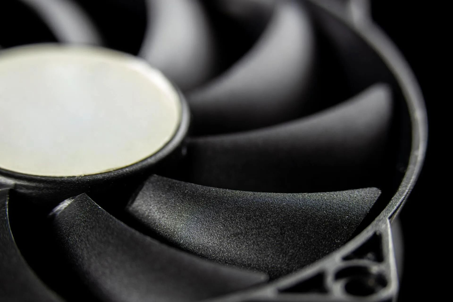 Close-Up of A Black Computer Fan with Curved Blades and A White Central Hub — Lakeside Gas Fridges In Argenton, NSW