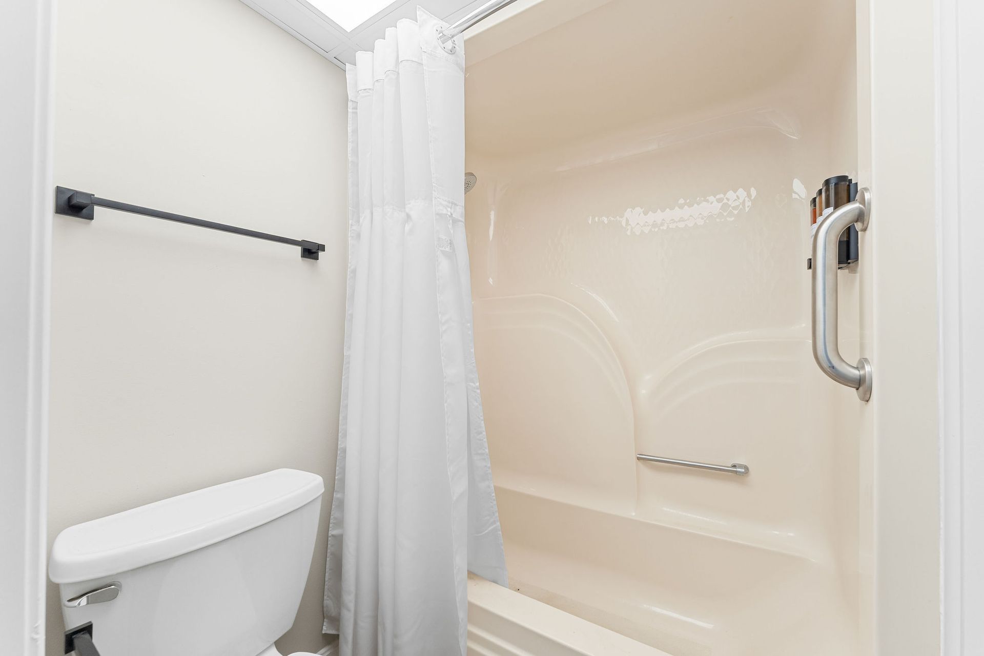 A bathroom with a toilet , bathtub and shower curtain.