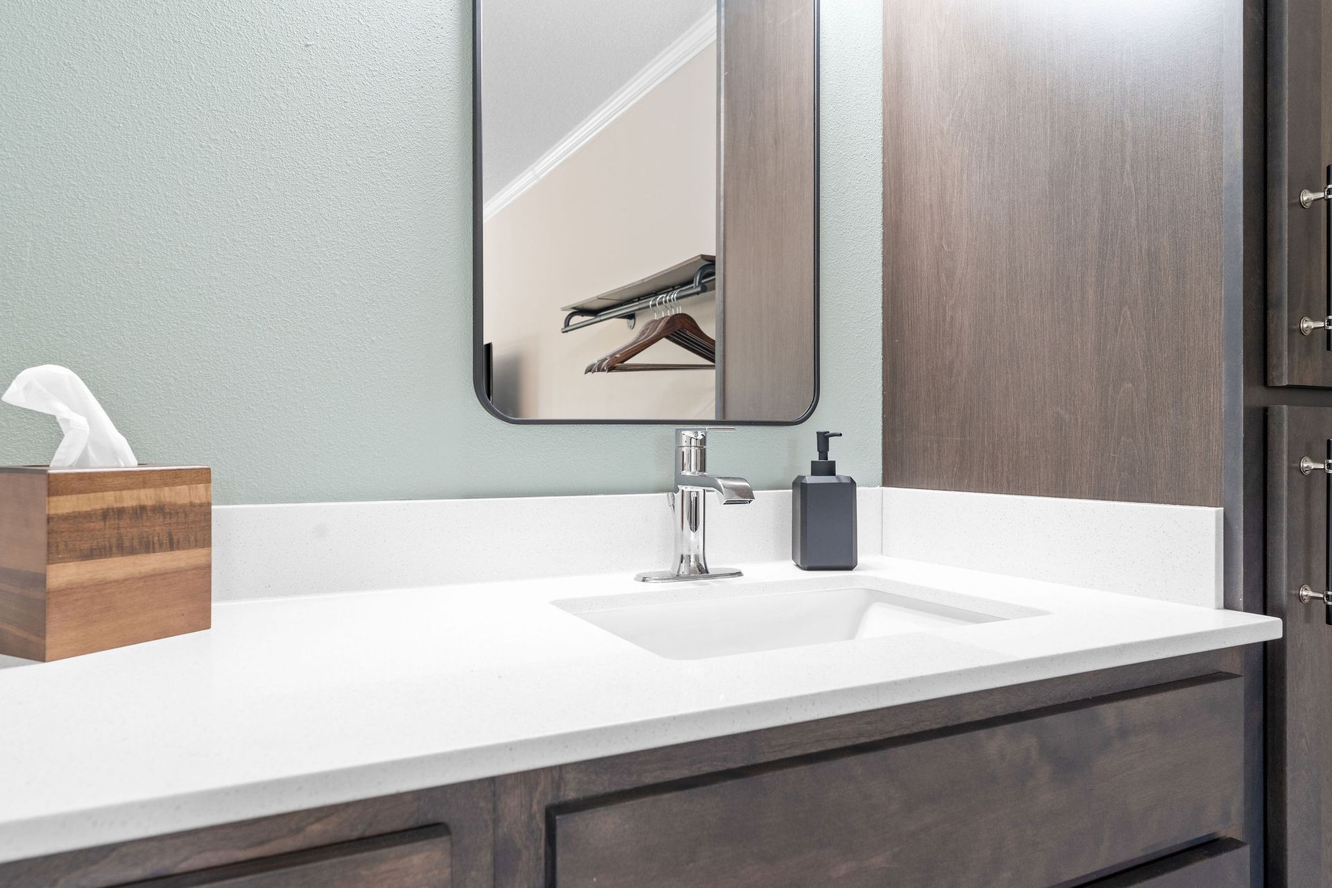 A bathroom with a sink , mirror and tissue box.