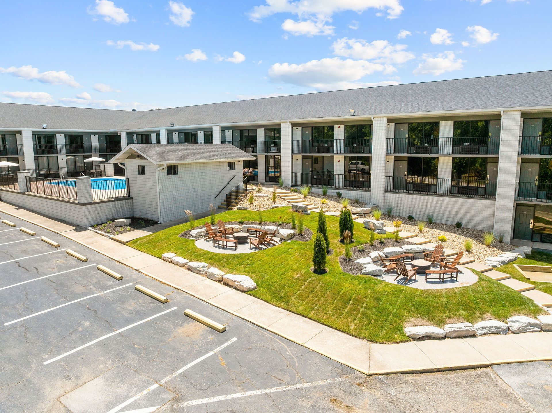 An aerial view of a hotel with a fire pit in the middle of the courtyard.