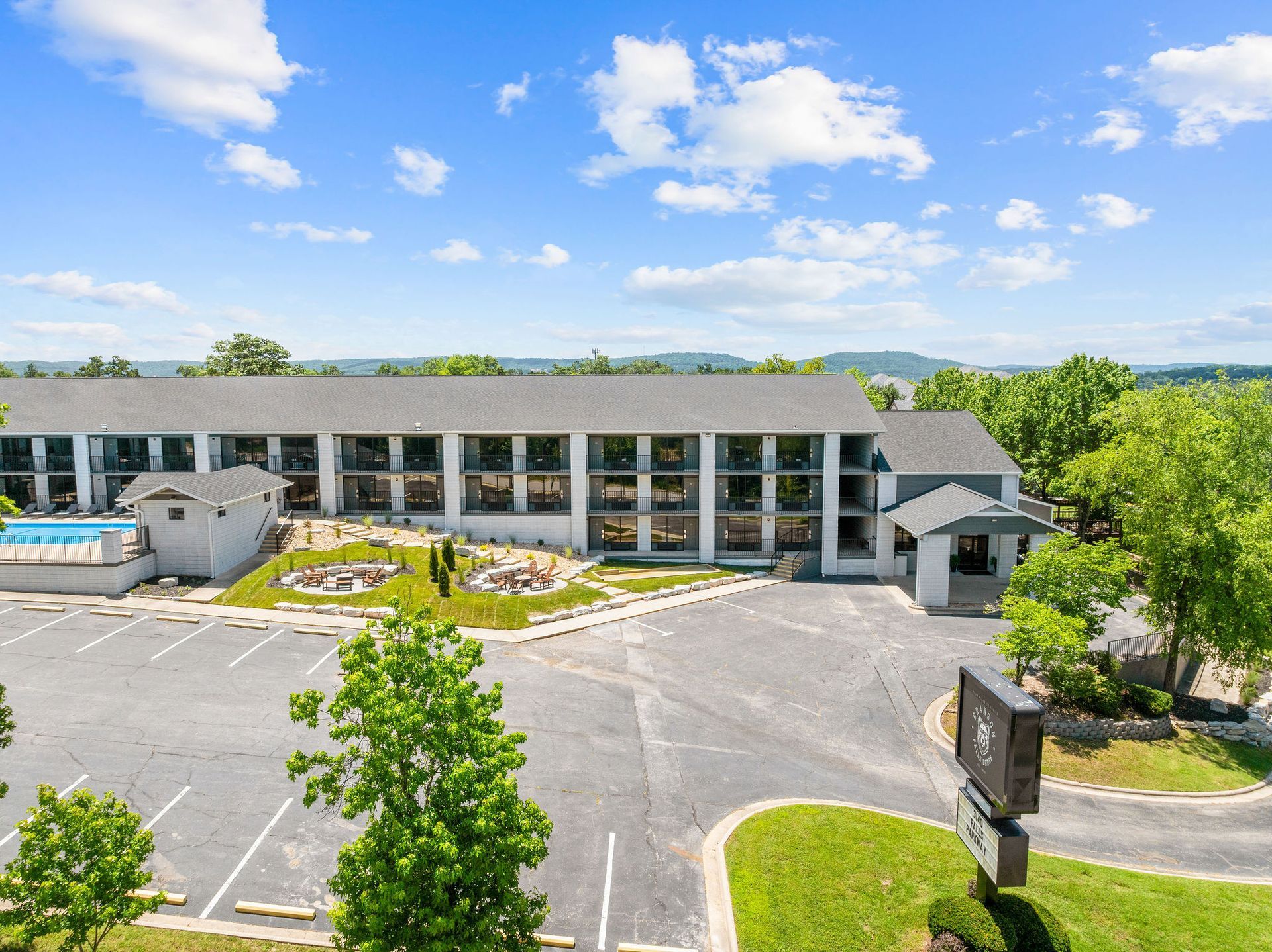 An aerial view of a hotel with a pool in the background.