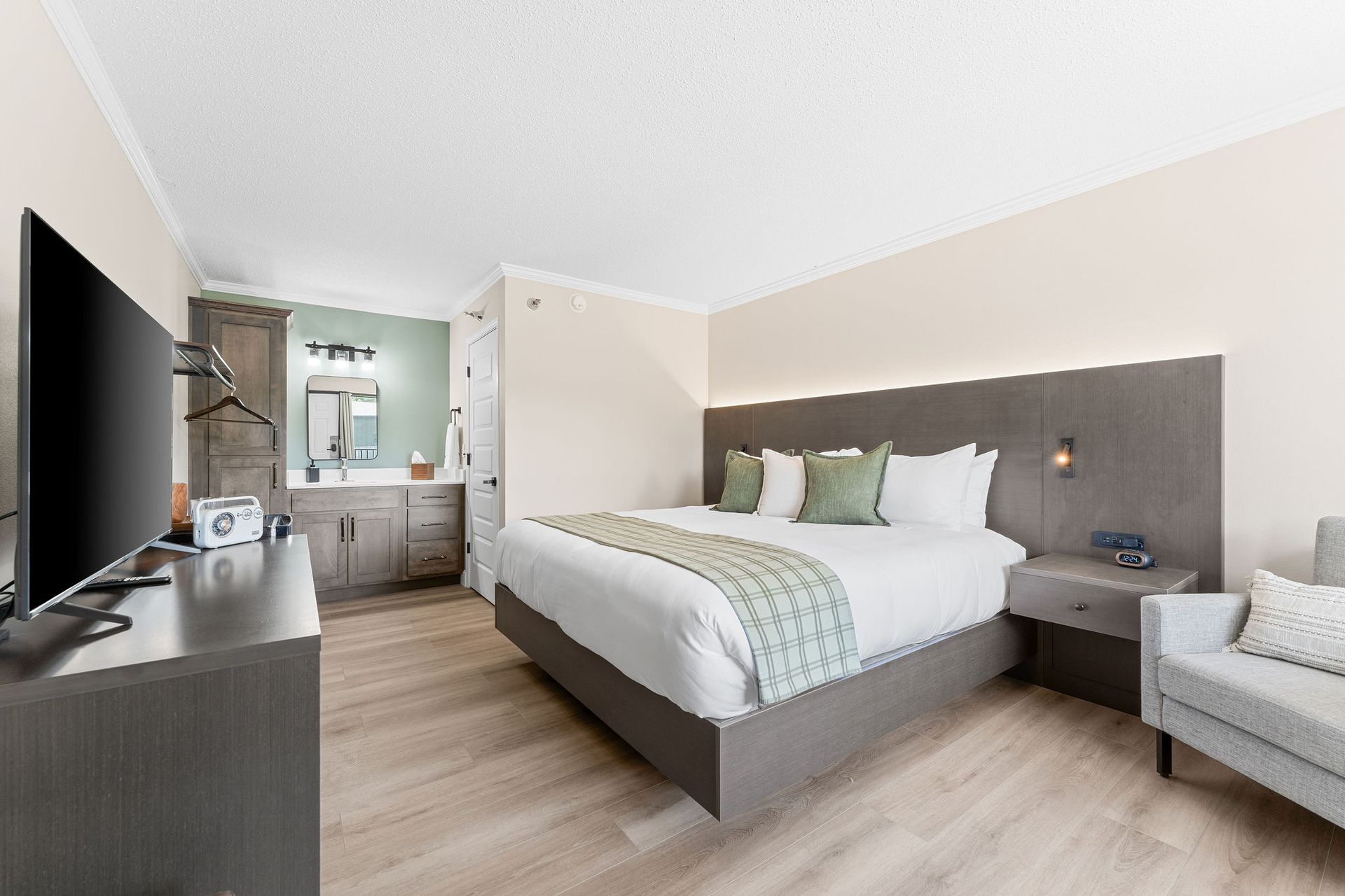 A hotel room with a king size bed and a flat screen tv