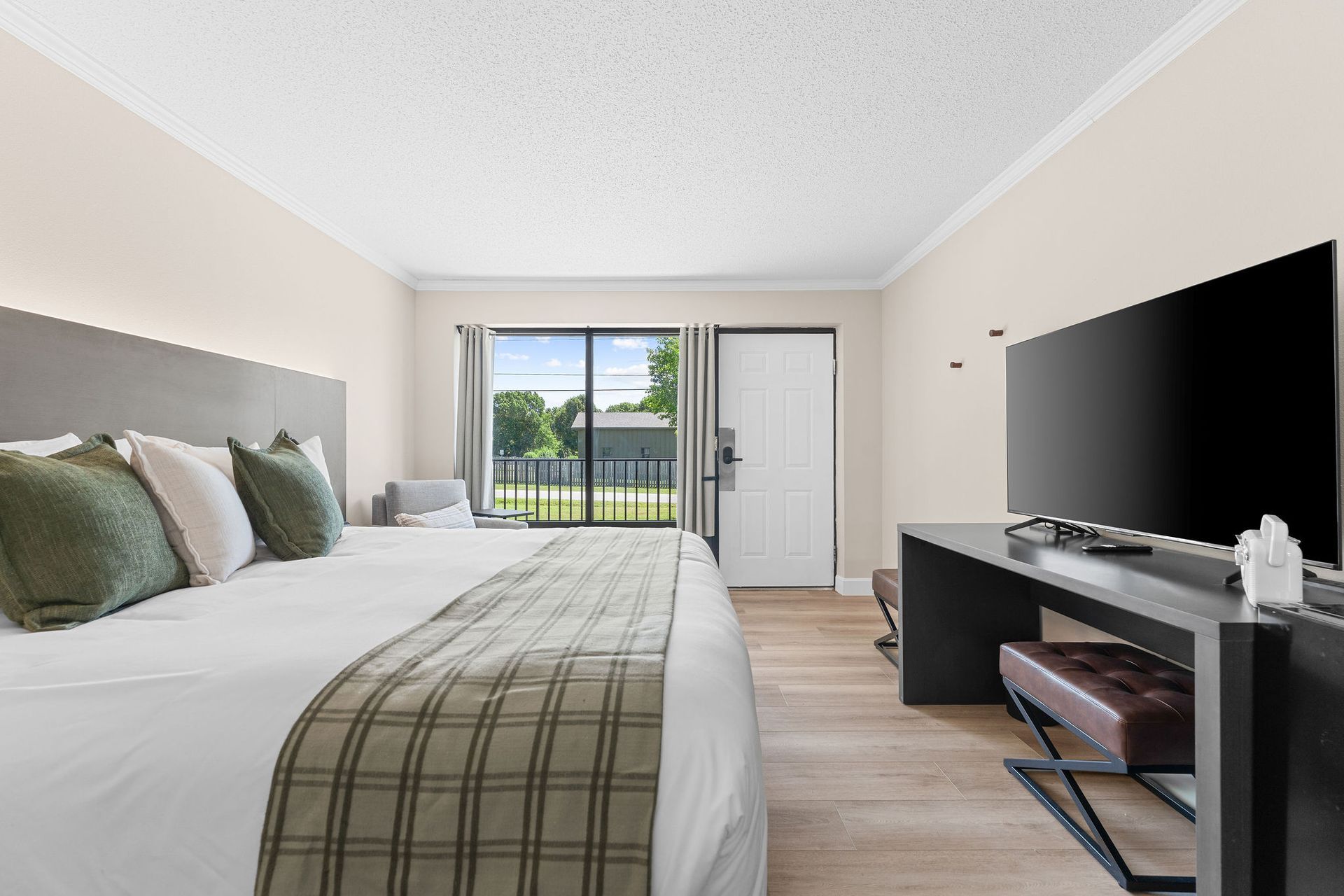 A hotel room with a large bed and a flat screen tv.