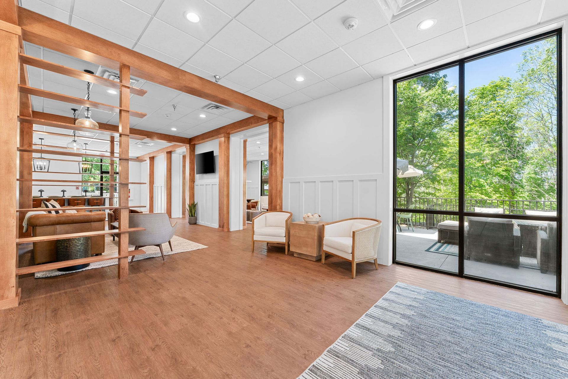 A living room with a lot of windows and chairs.