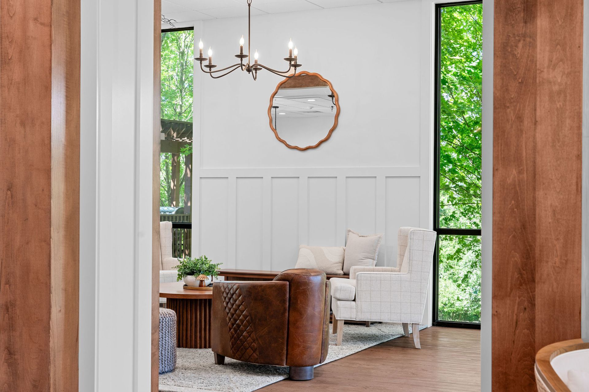 A living room with a couch , chair , table and mirror.