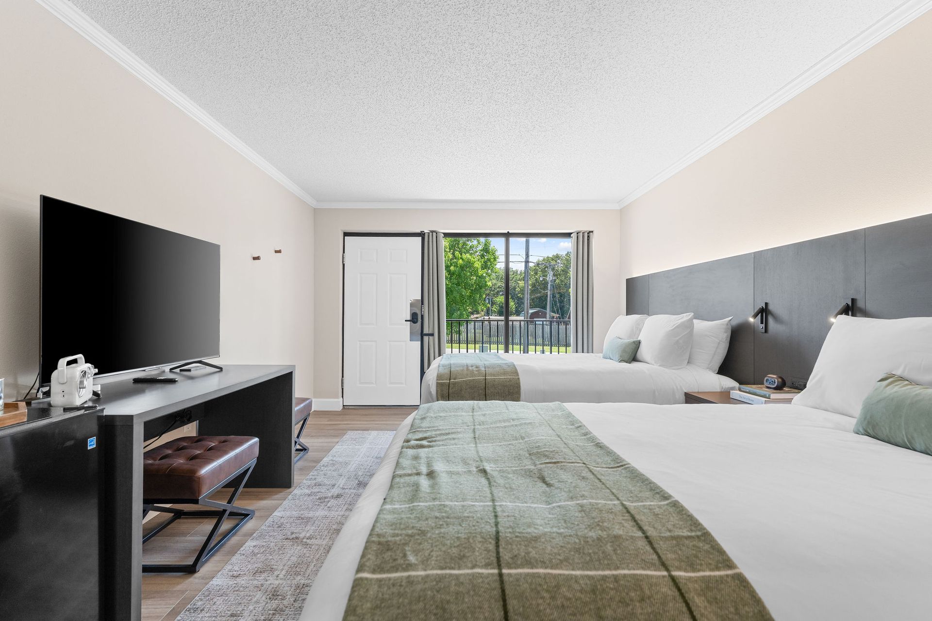 A hotel room with two beds and a flat screen tv.