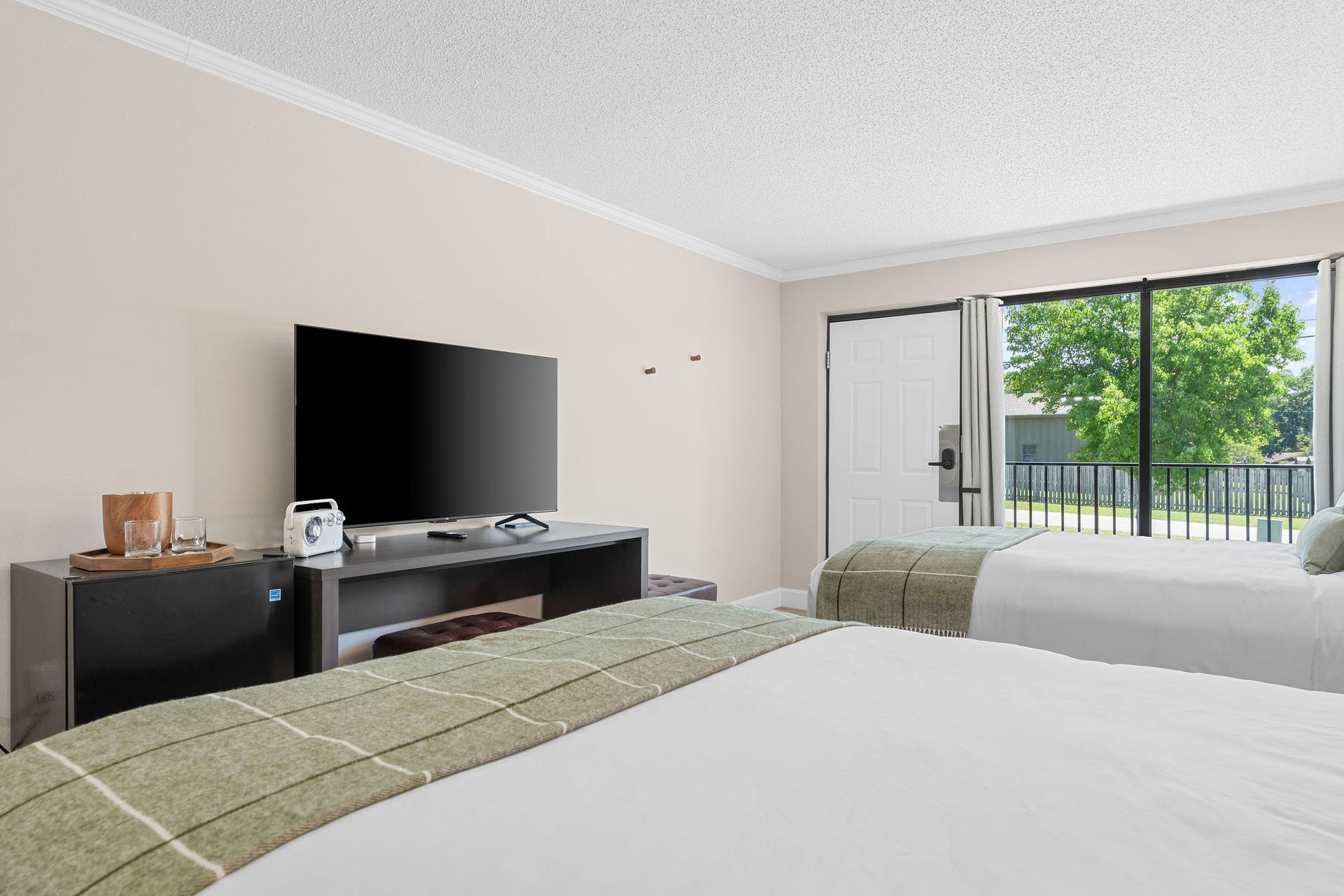 A hotel room with two beds and a flat screen tv.