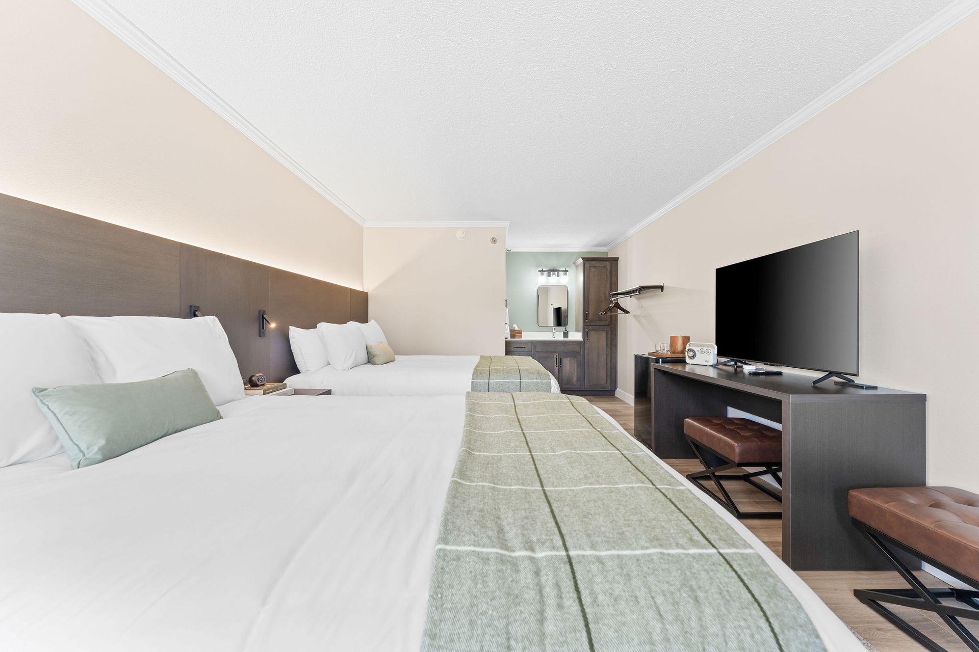 A hotel room with two beds and a flat screen tv.