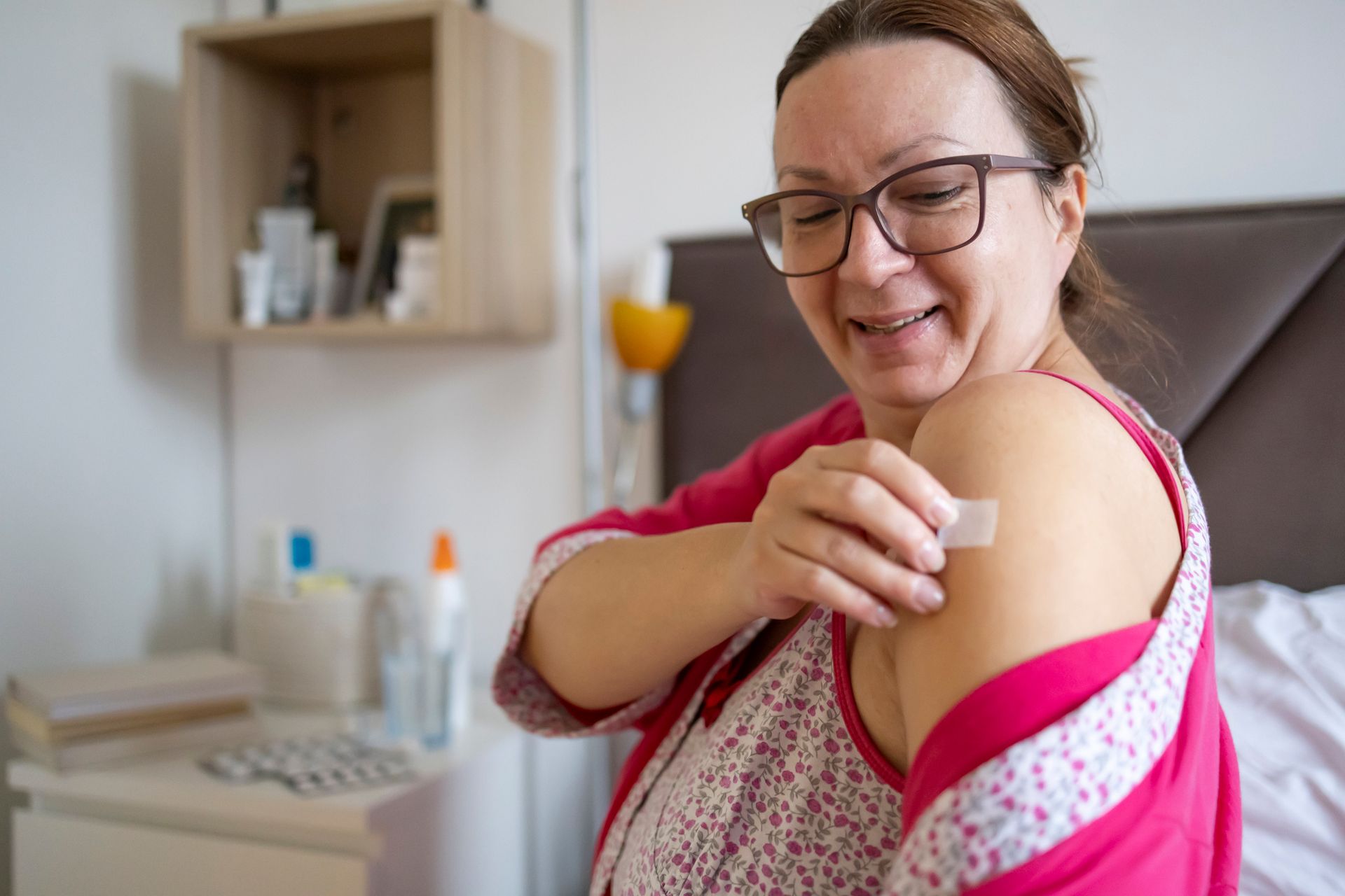 A beautiful mature woman applies a transdermal patch as hormonal therapy in menopause