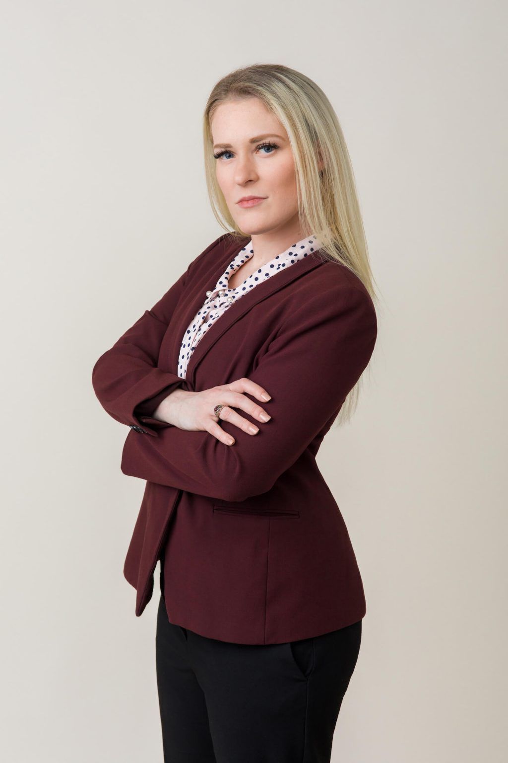 A man in a suit and tie is standing in front of a window.