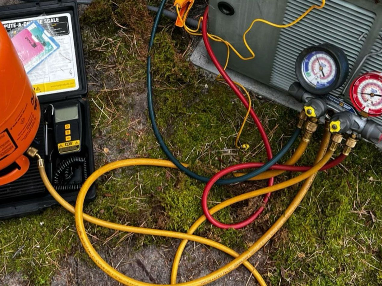 HVAC equipment being serviced outdoors; gauges, hoses, and instruments connected to a unit.