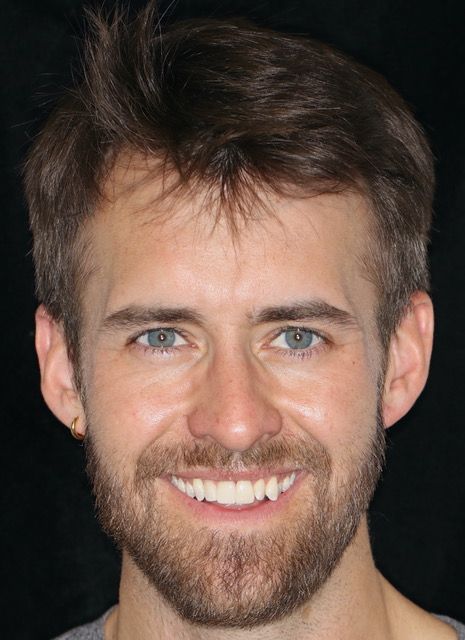 A man with a beard and blue eyes is smiling for the camera.