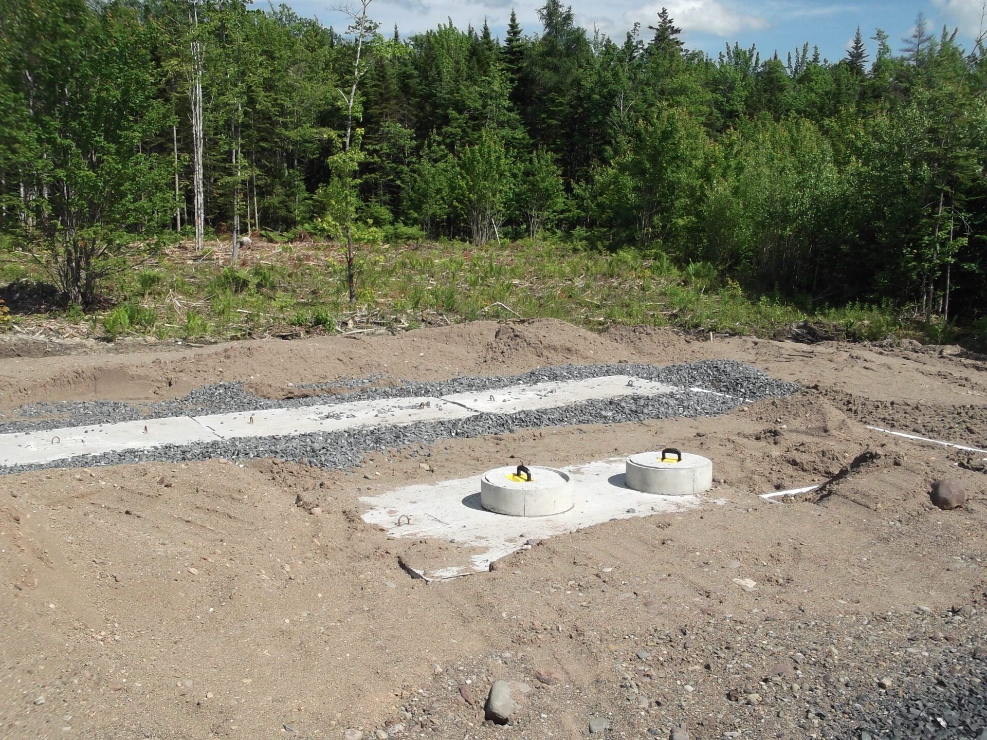 Two concrete blocks are sitting in the middle of a dirt field